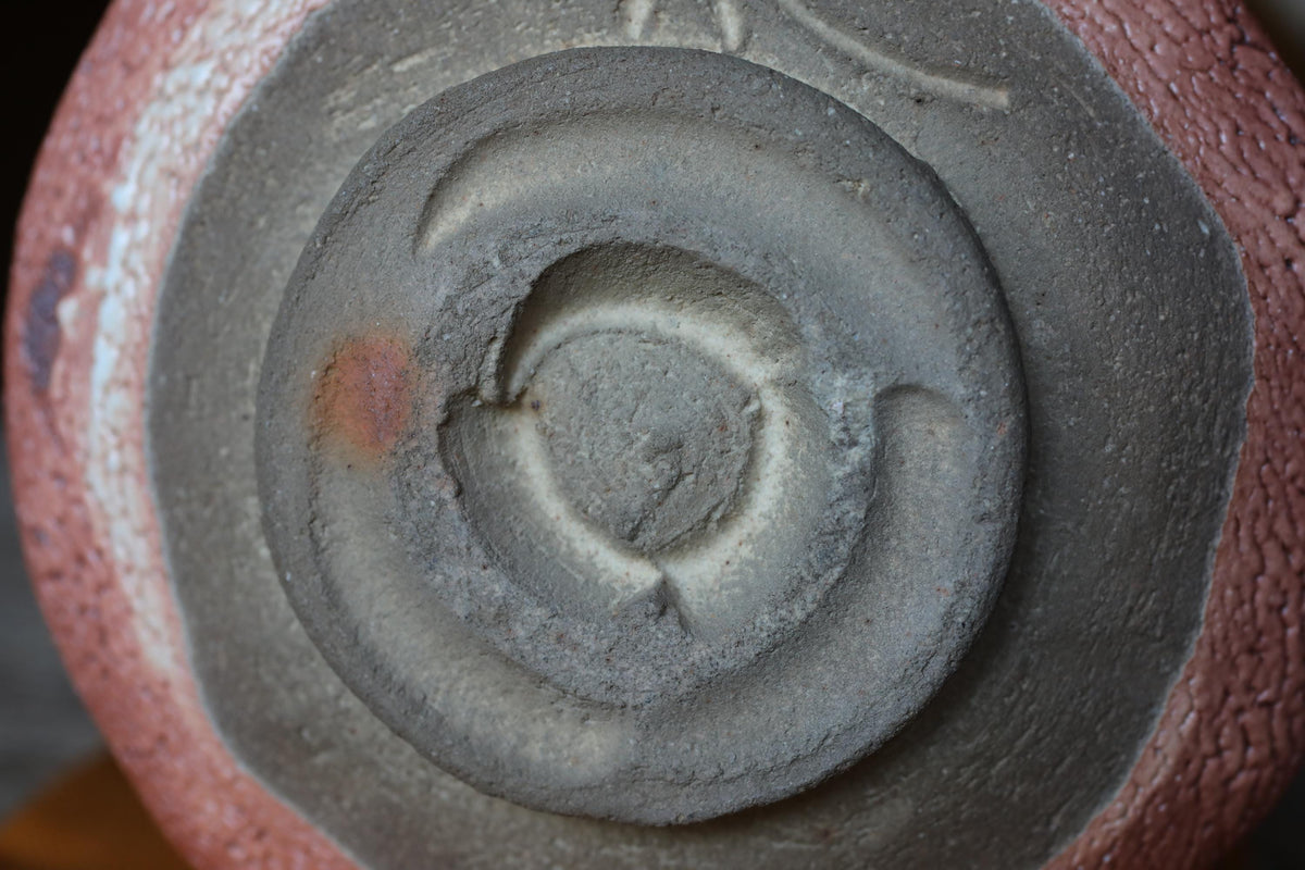 a close-up view of a ceramic or pottery piece with a distinctive circular design or pattern on its surface.