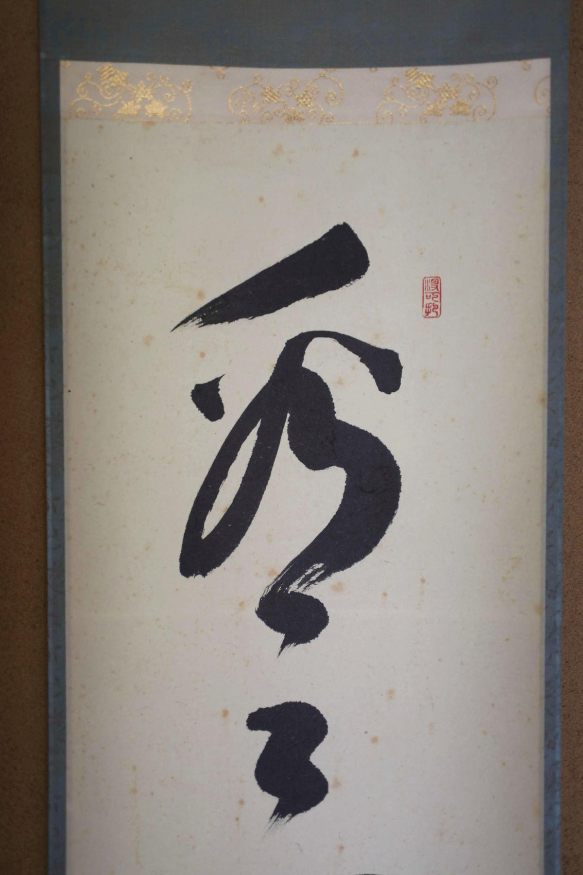a black brush stroke on a white background, which appears to be a calligraphic or artistic representation.