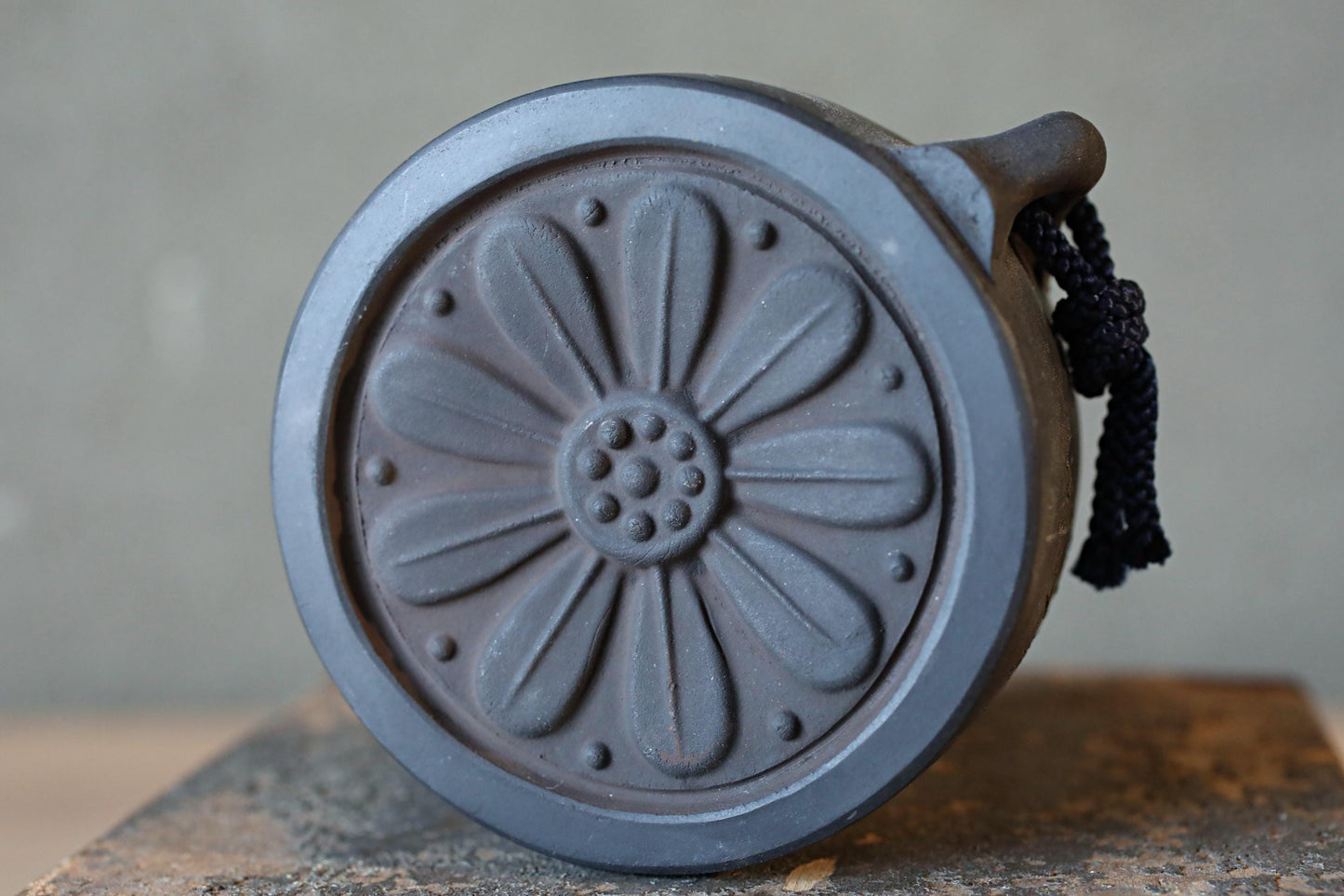 A close-up view of a decorative metal object with a flower-like design on its surface.