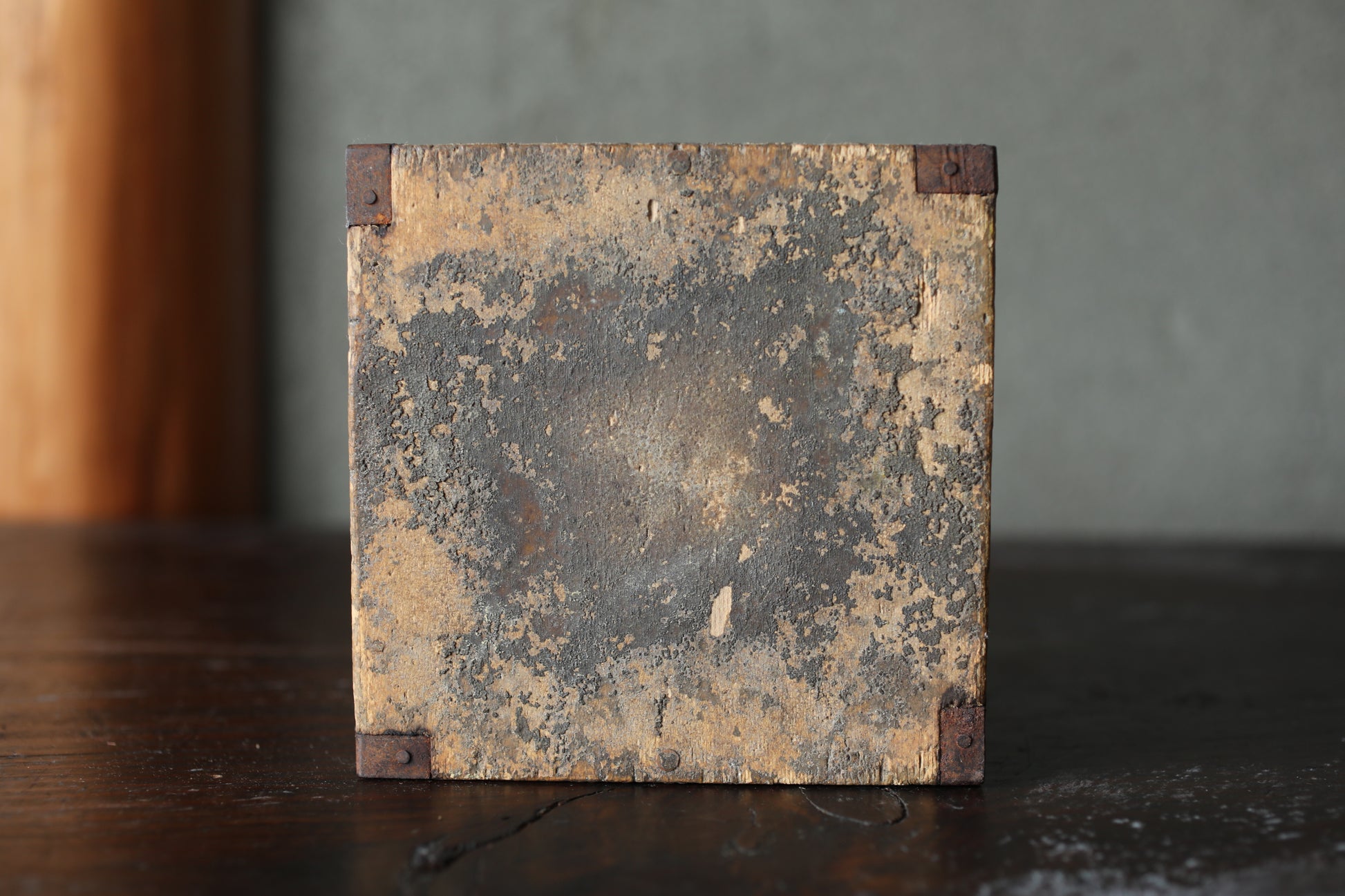 a weathered, wooden surface with a worn, peeling paint surface.
