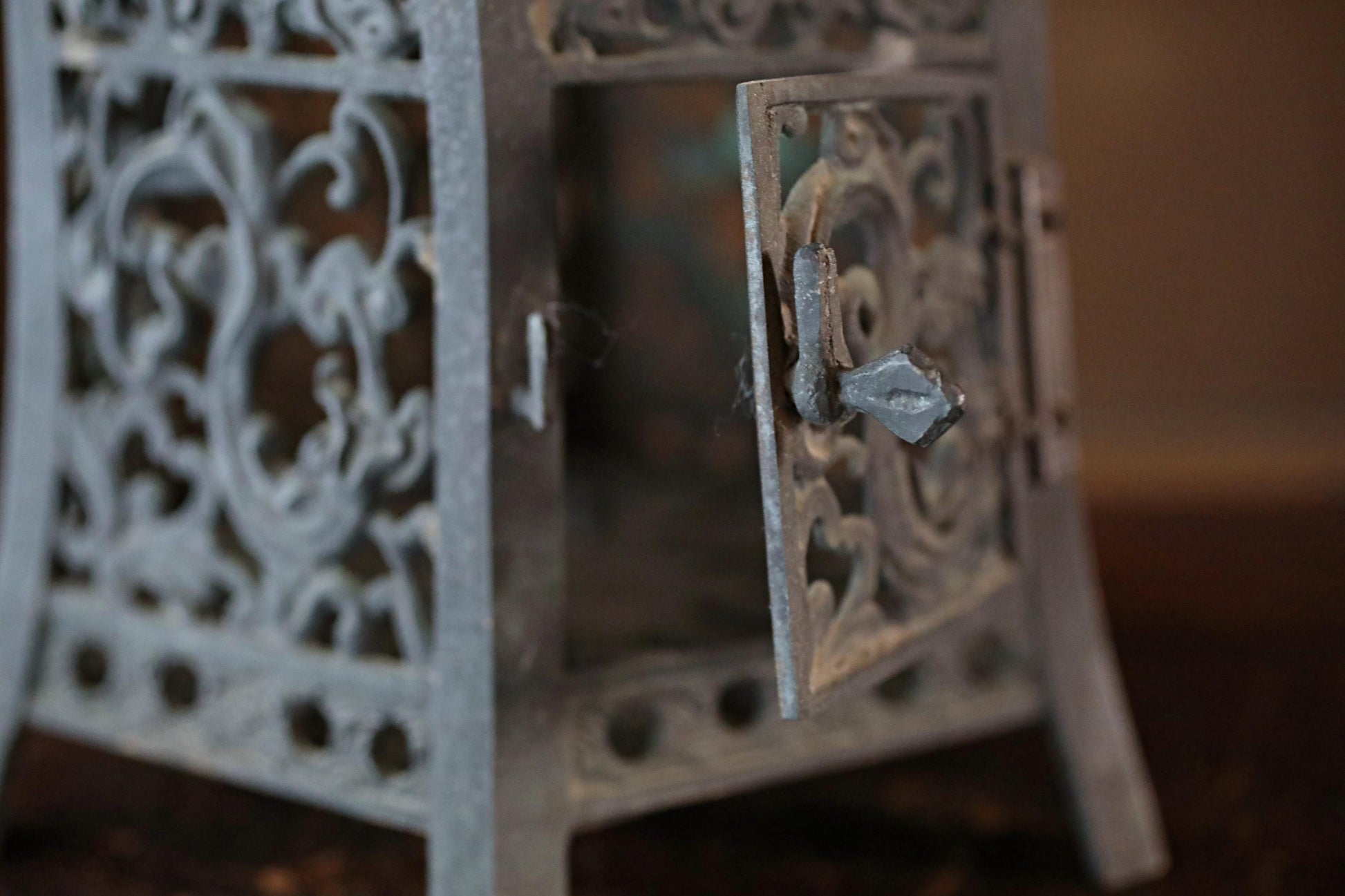 a close-up view of an ornate metal lantern with intricate designs and a keyhole.