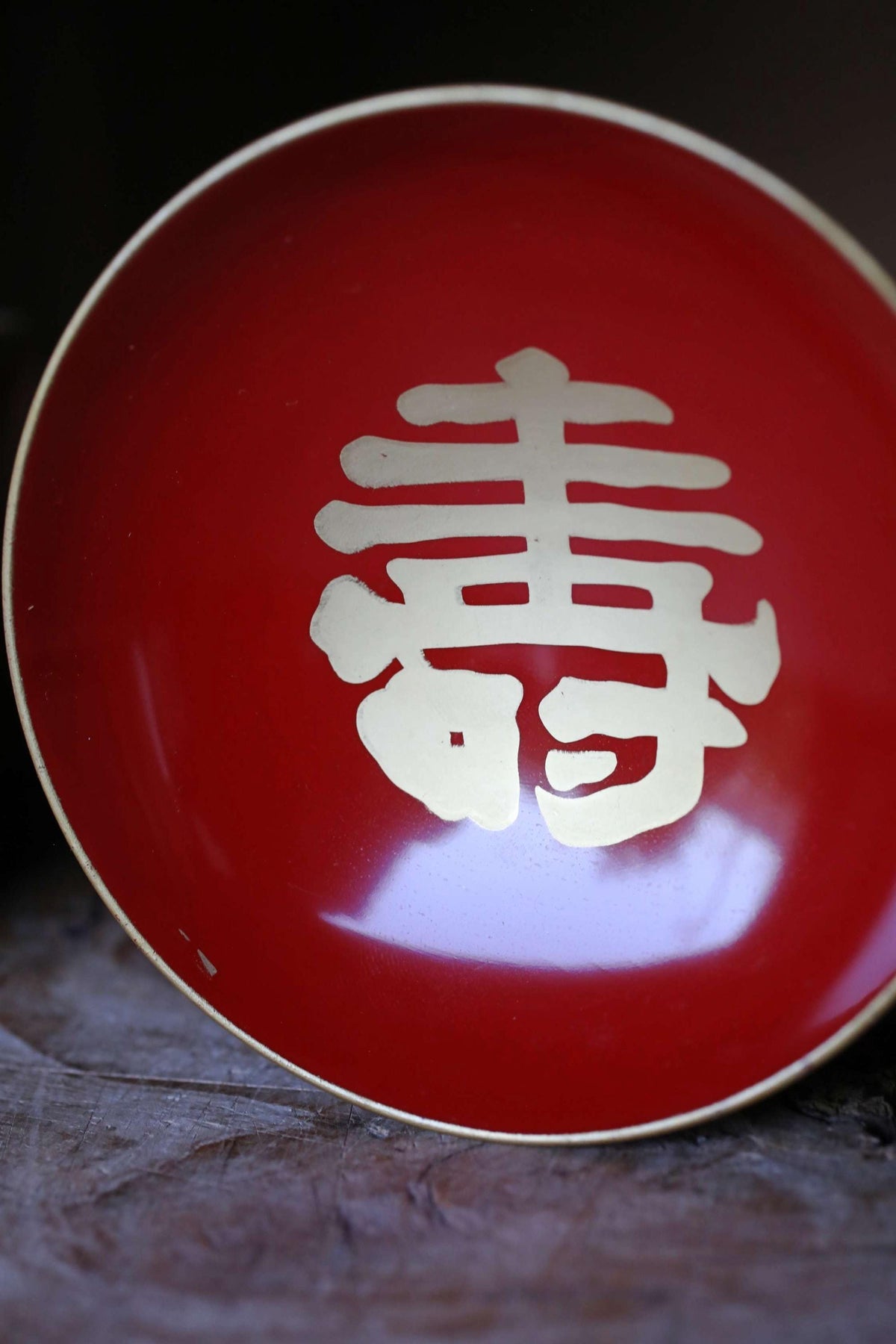 A red bowl with a white Chinese character on it.