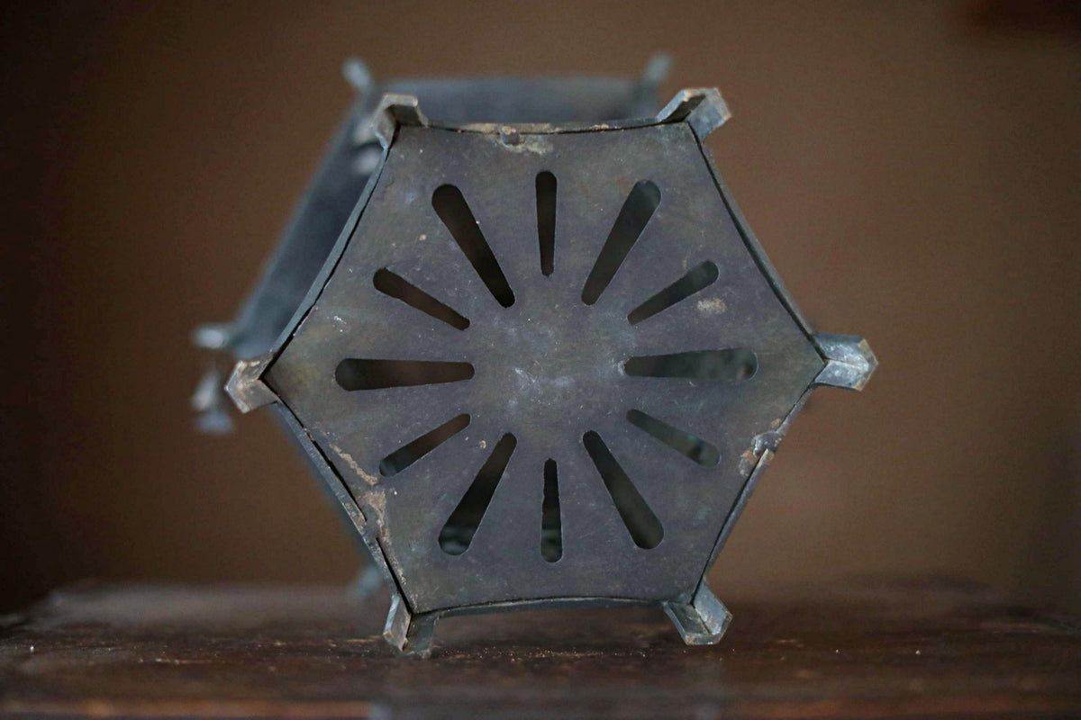 a close-up view of a metal object with a hexagonal cutout in the center, which appears to be a piece of art or a decorative item.