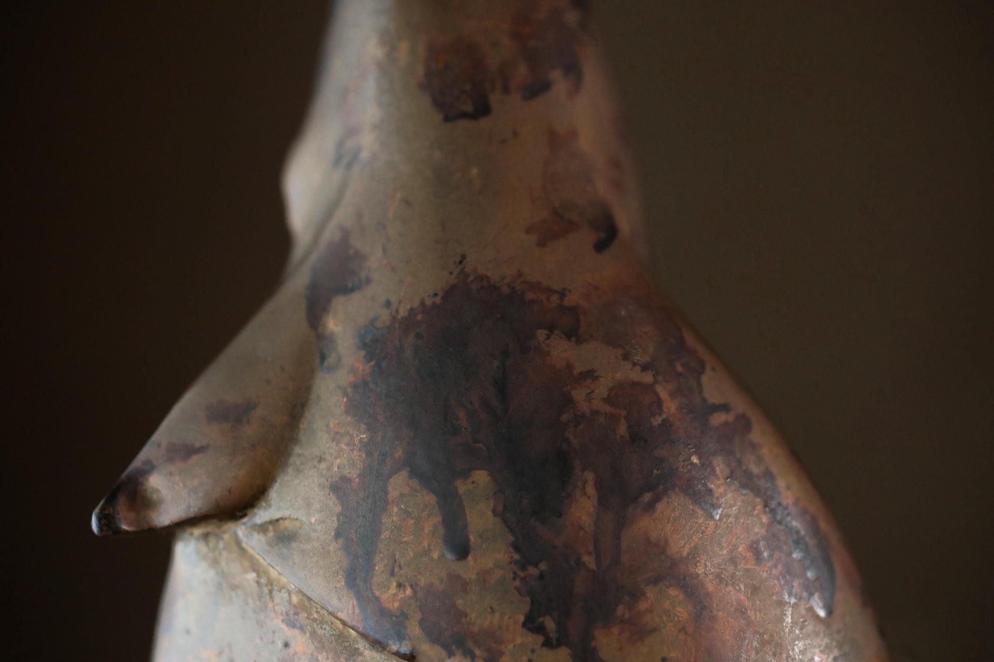 a close-up view of a weathered, rusted metal object, possibly a piece of art or a sculpture.