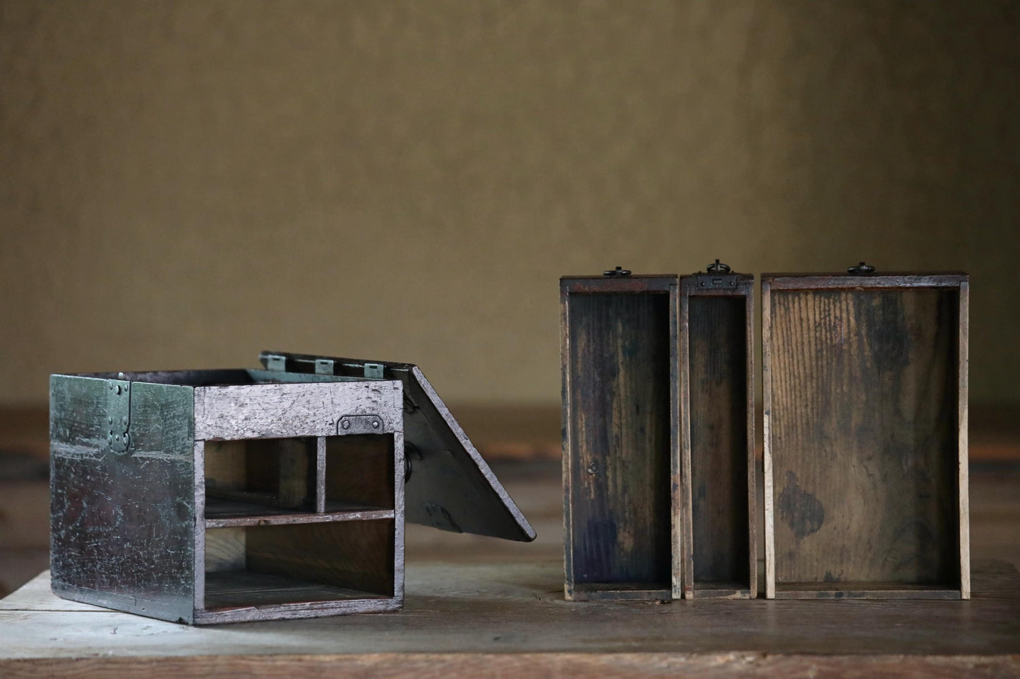 two wooden boxes, one with the lid open and the other closed, placed on a wooden surface against a plain background.