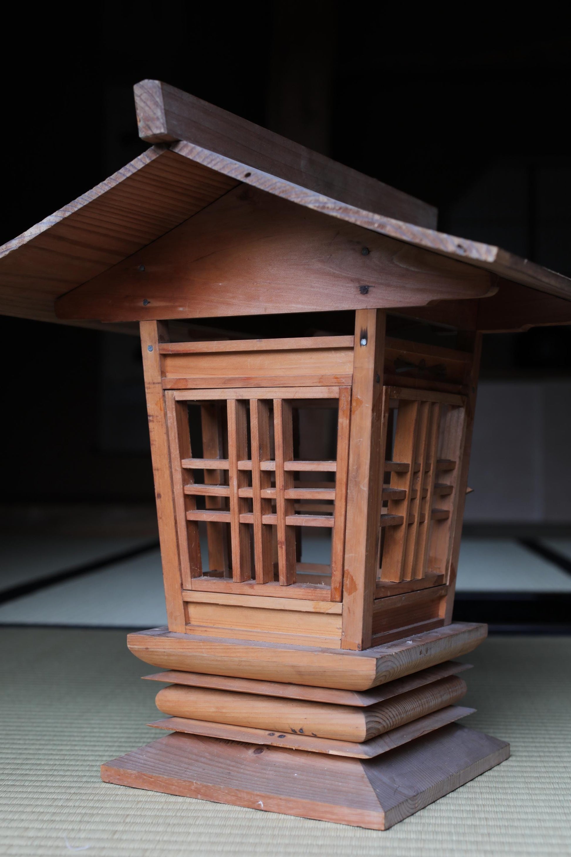 a wooden structure with a slanted roof and a lattice-like design on the front.
