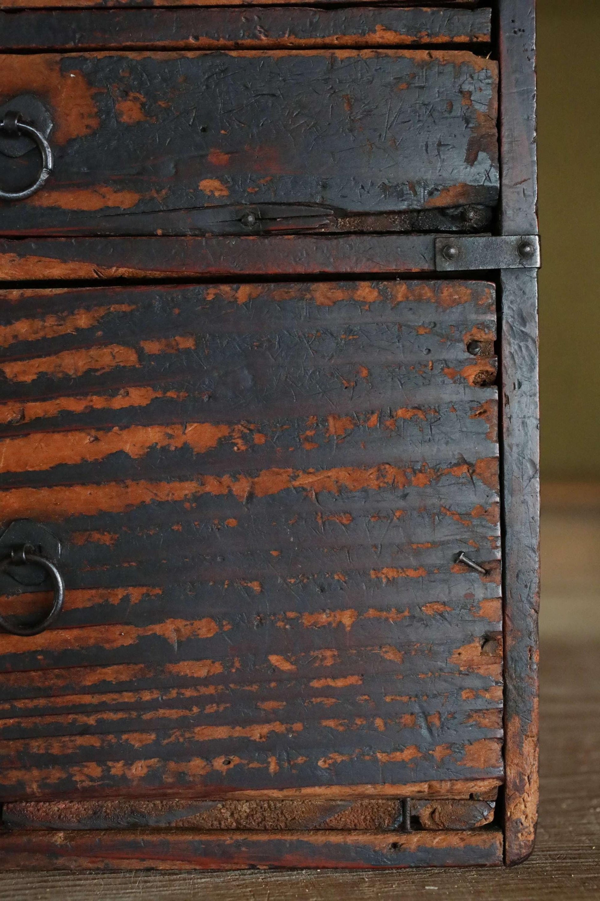 a close-up view of a weathered, wooden drawer with peeling paint and rust, giving it a vintage, antique appearance.