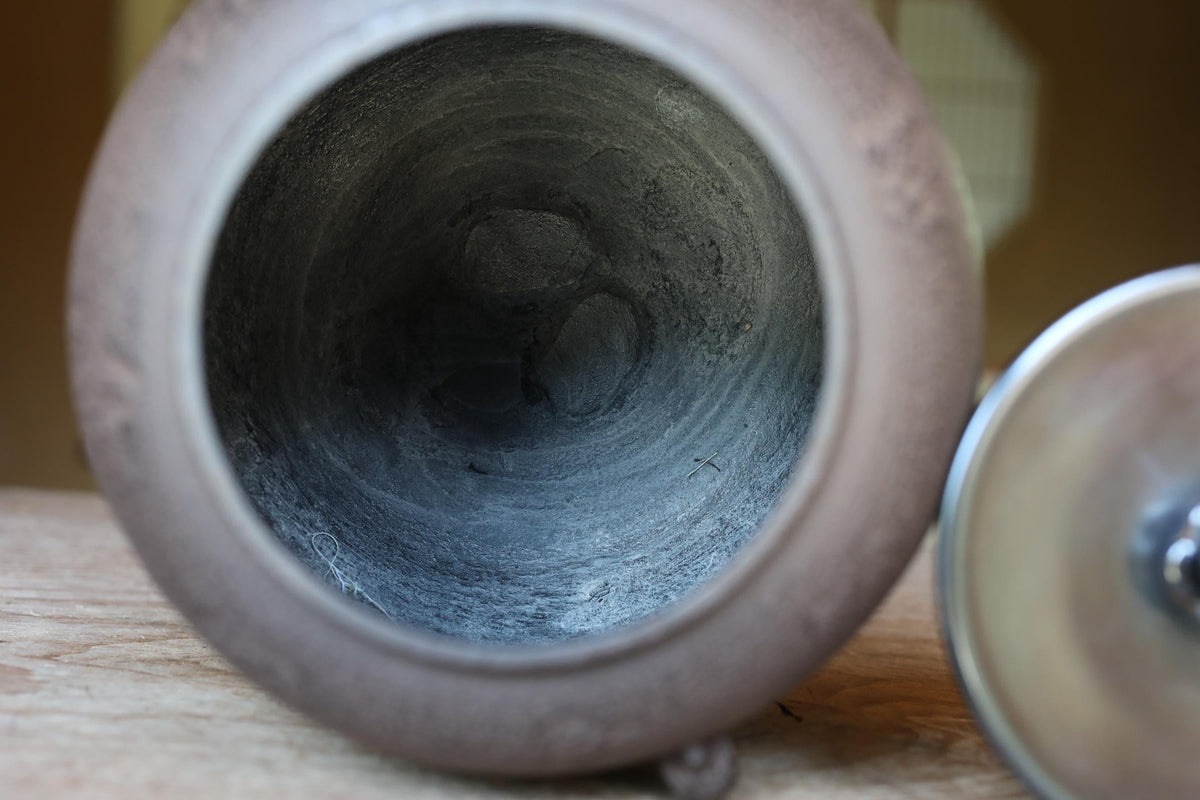 the inside of a ceramic container, possibly a vase or a bowl, with a dark, textured interior.