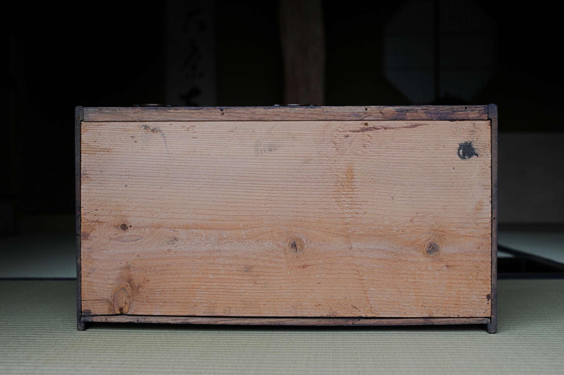a wooden box with a dark finish, sitting on a surface.