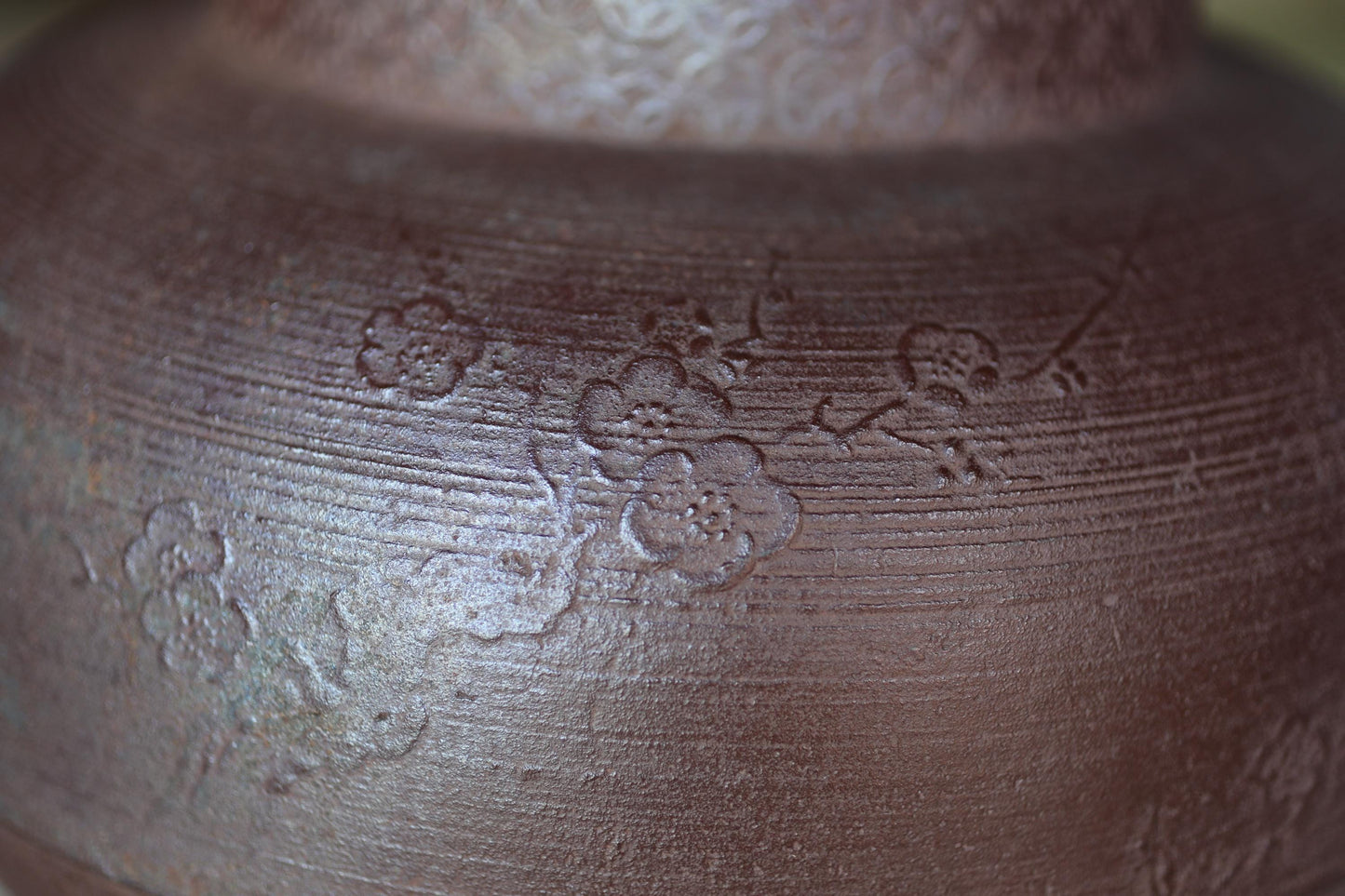 A close-up image of a textured brown surface with a floral pattern, featuring a few distinct flower-like designs.