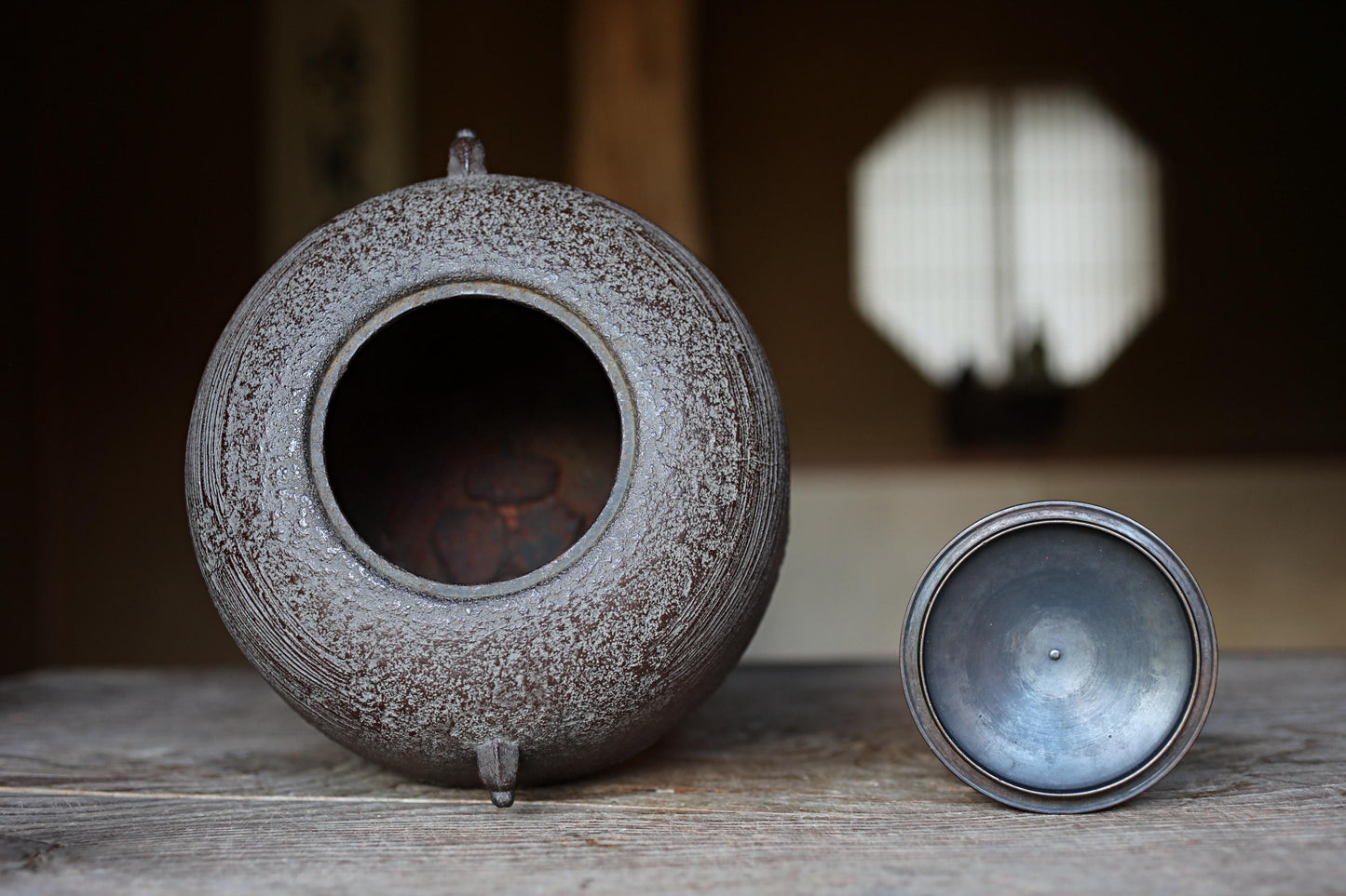 a large, round, metal container with a hole in the center, sitting on a wooden surface.