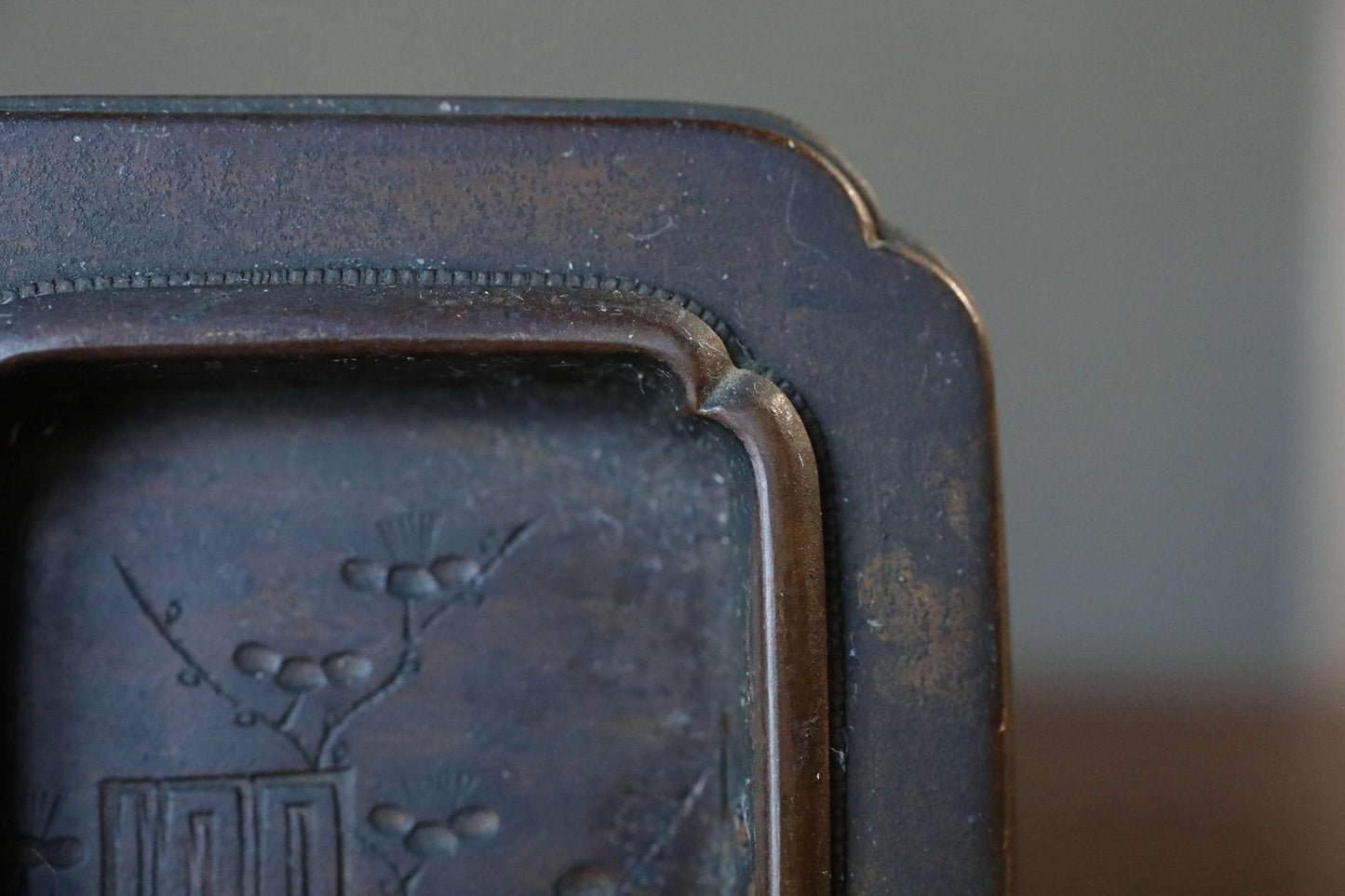 a close-up view of a dark brown, ornate metal object with a decorative design on its surface.