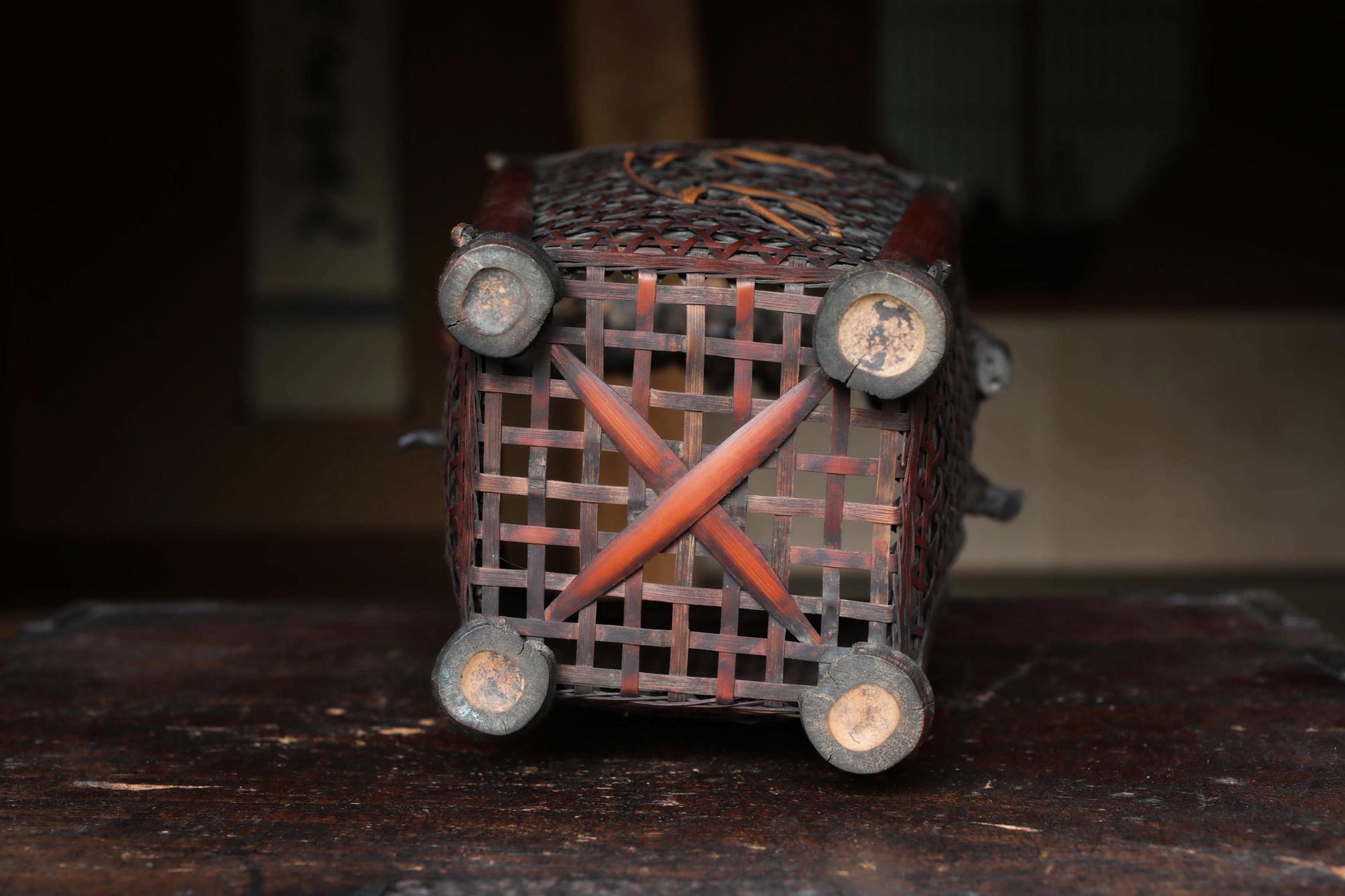 a wooden basket with a woven design, placed on a wooden surface.