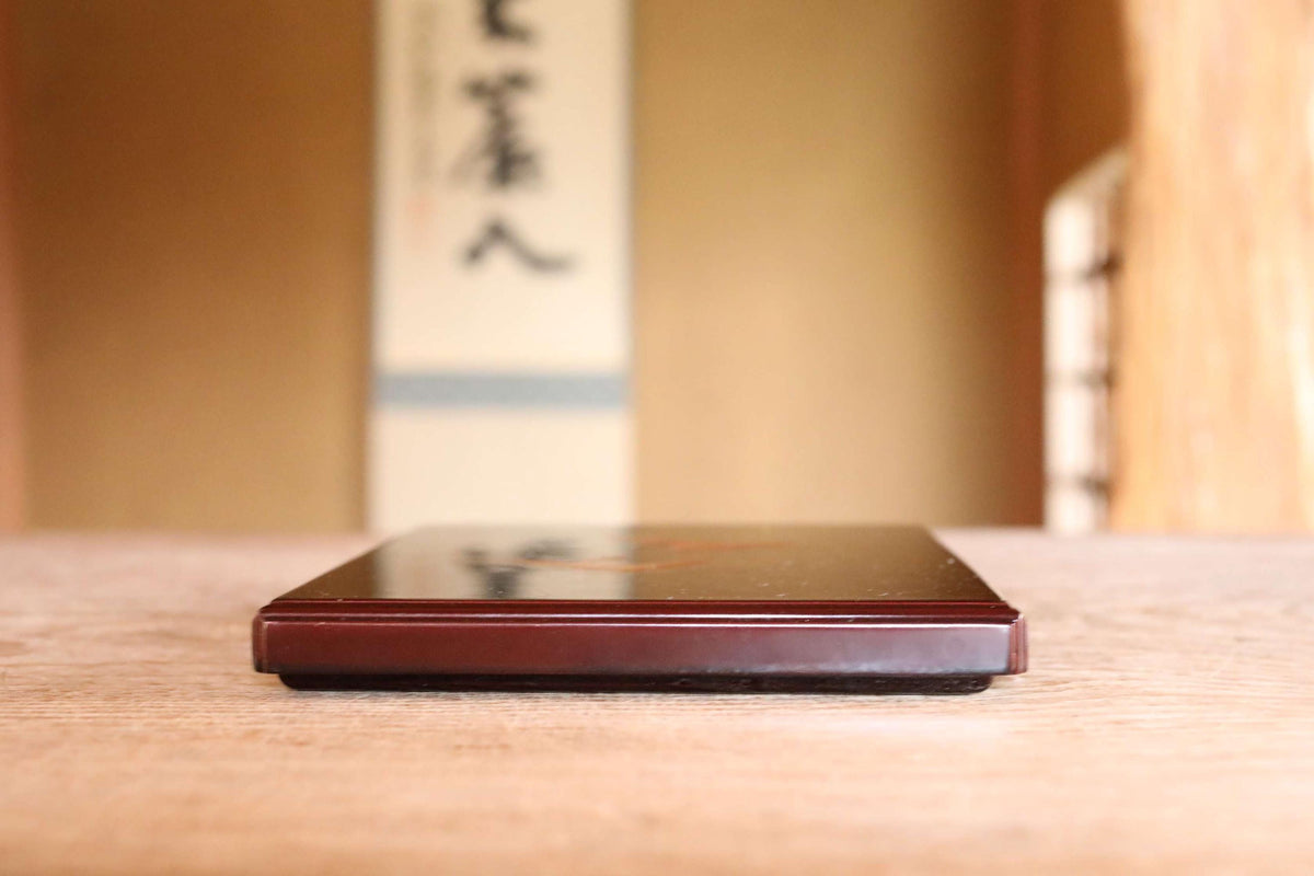 A wooden table with a dark-colored object, possibly a book or a decorative item, placed on it.
