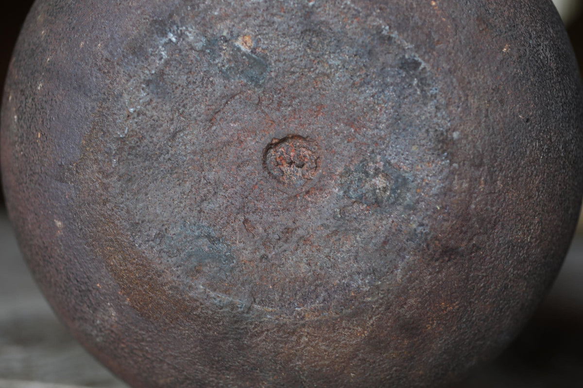 a close-up view of a rusted metal surface, with a large, circular hole in the center.