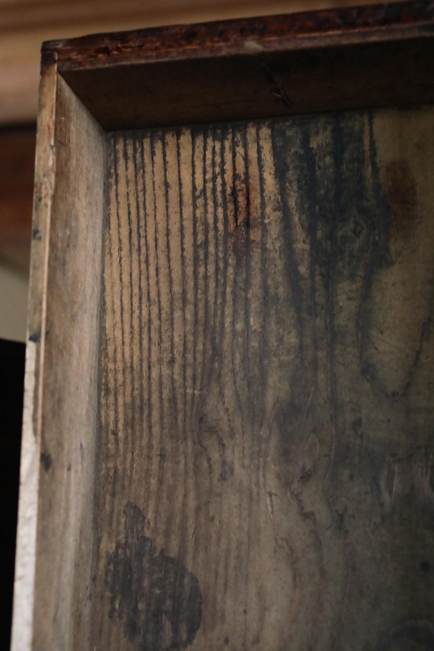 a close-up view of a wooden surface with a textured, weathered appearance.