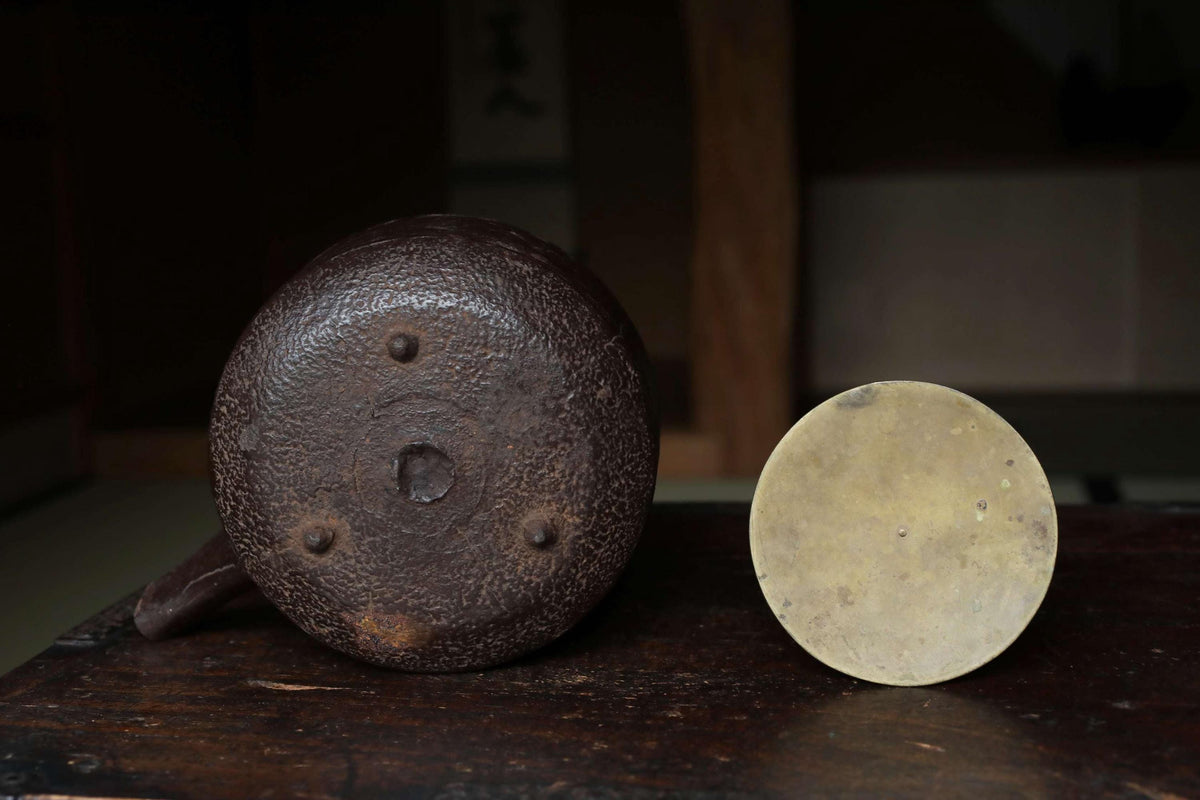 a round, brown object with a hole in the center, sitting next to a round, white object on a wooden surface.