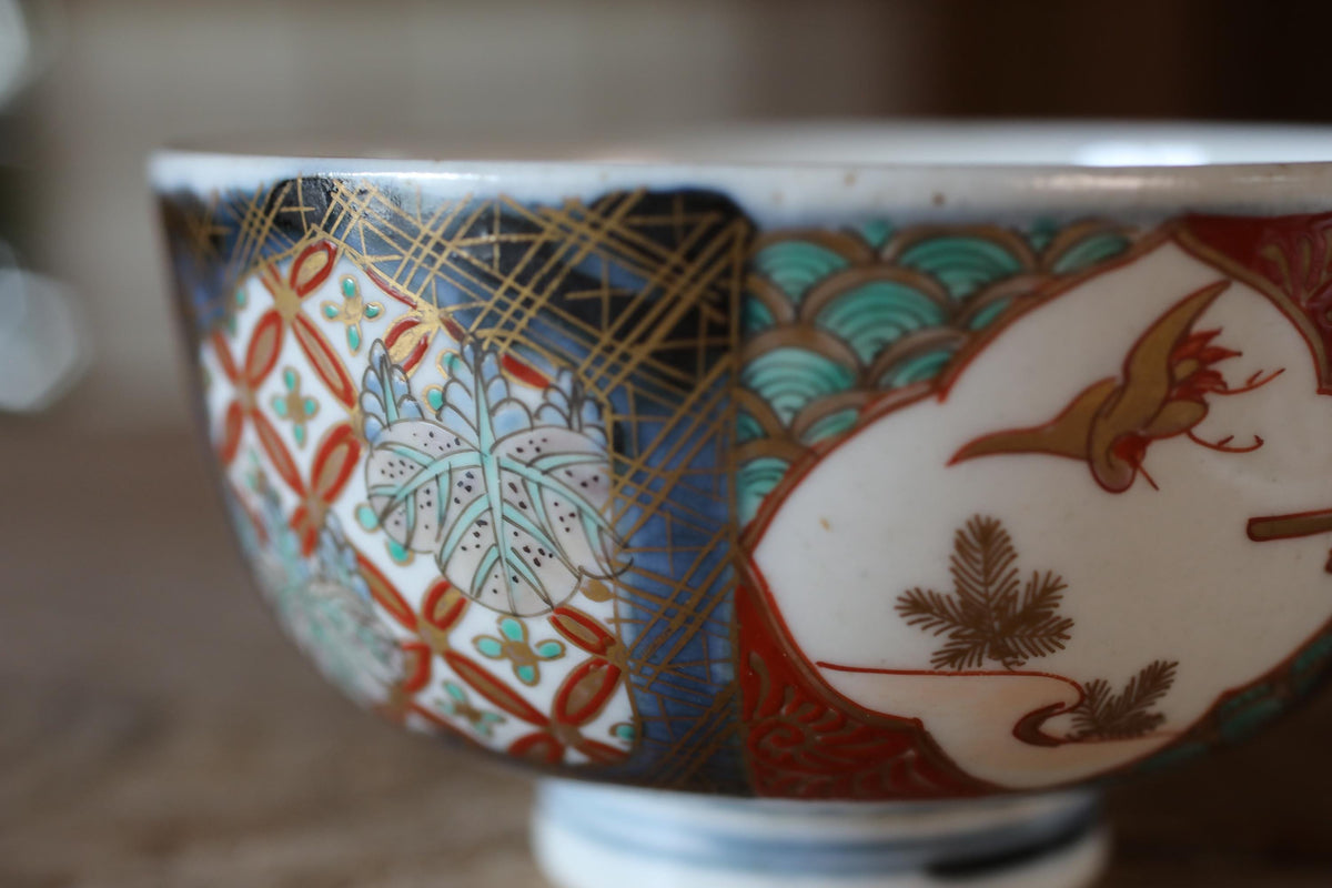 A close-up image of a decorative bowl with intricate patterns and designs, including a bird and floral motifs.