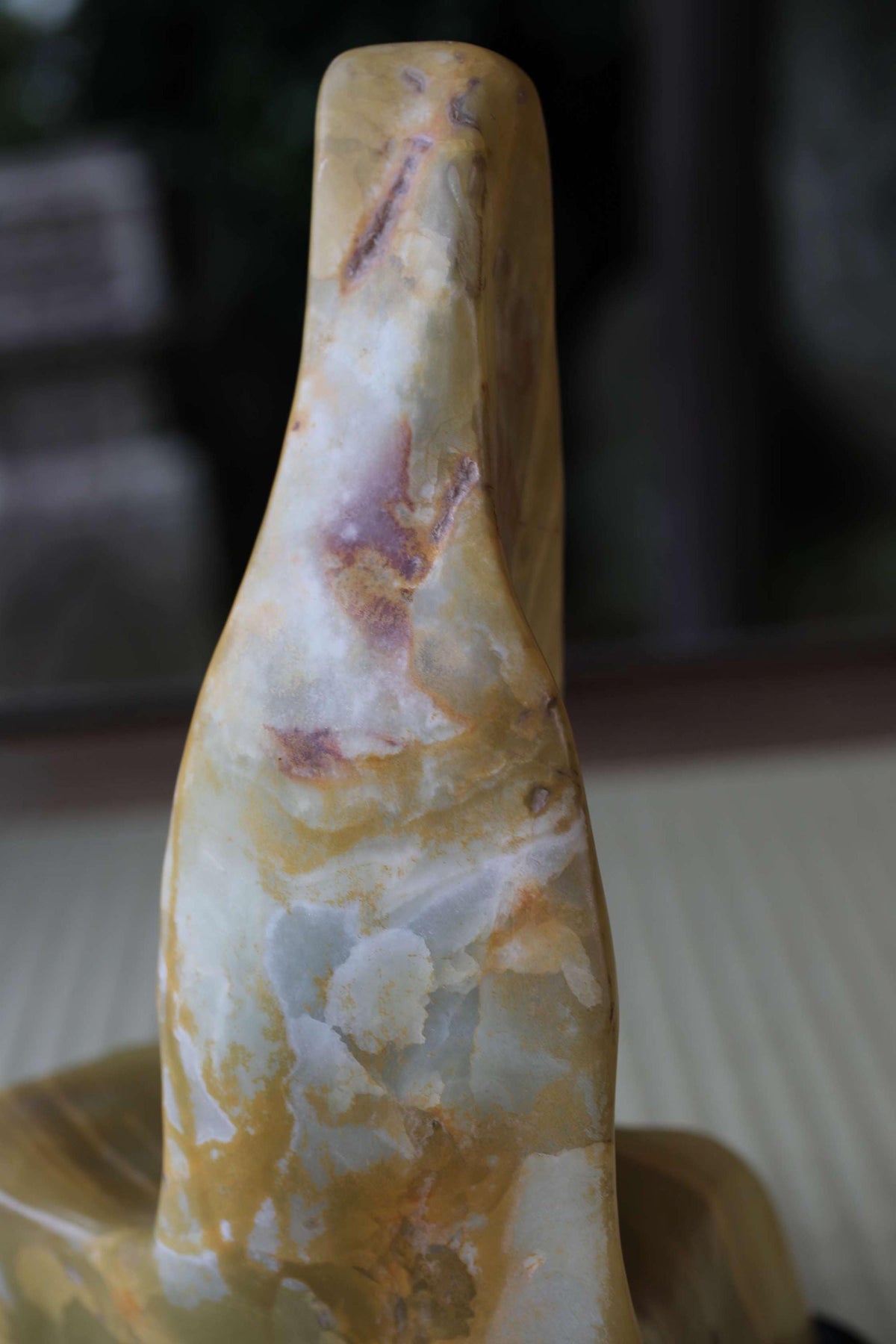 a close-up view of a stone sculpture with a textured, weathered appearance.
