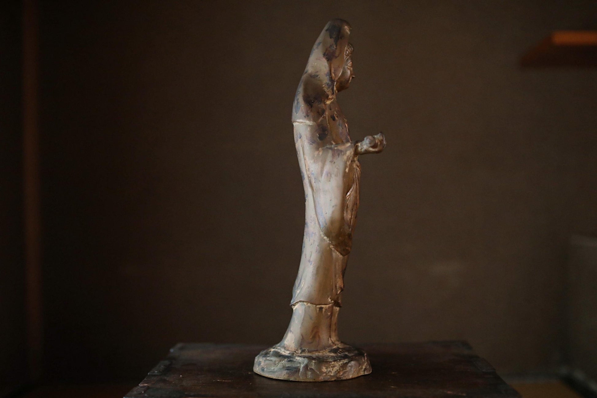 A bronze statue of a person standing on a pedestal.