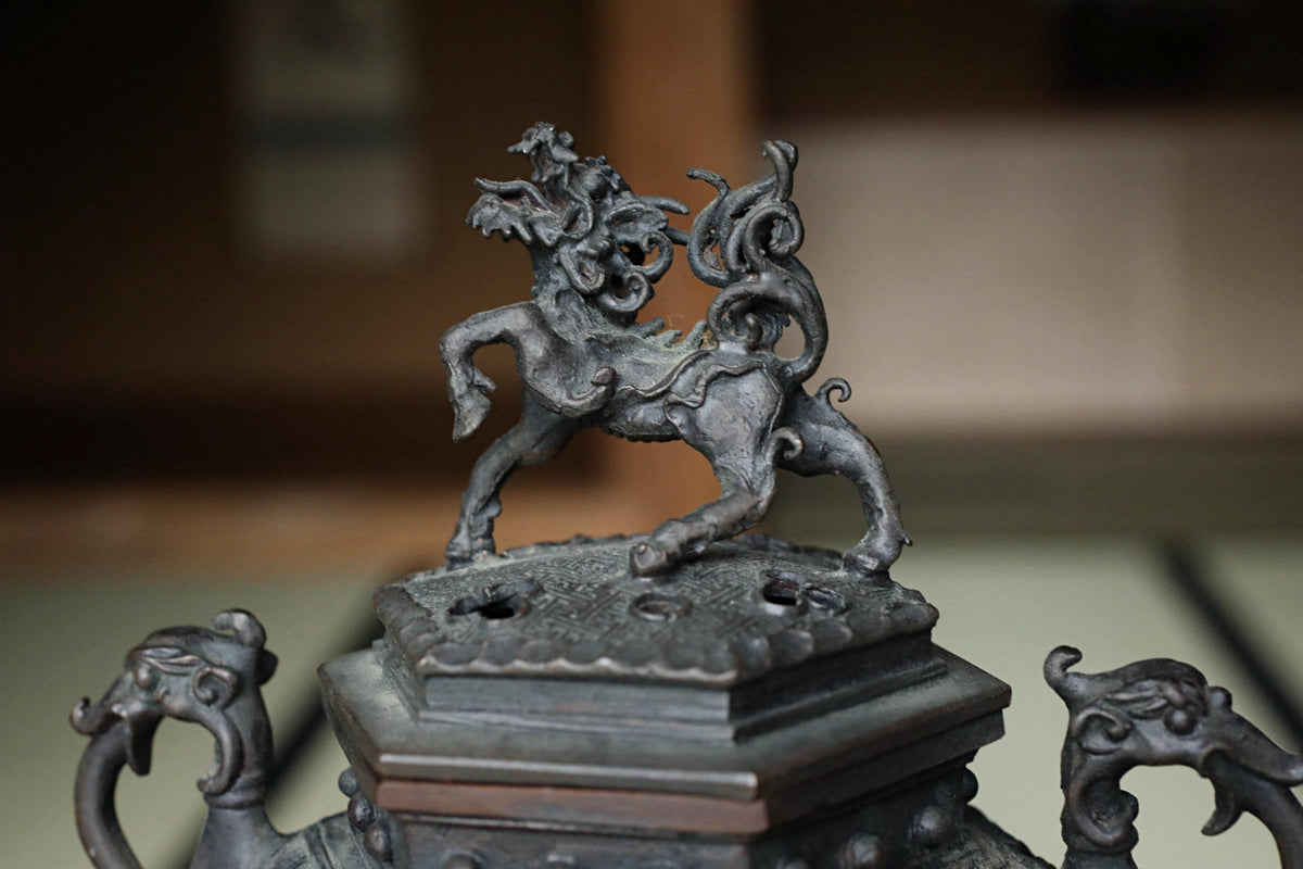 A close-up view of an ornate metal sculpture depicting a mythical creature, possibly a dragon or unicorn, on a decorative base.