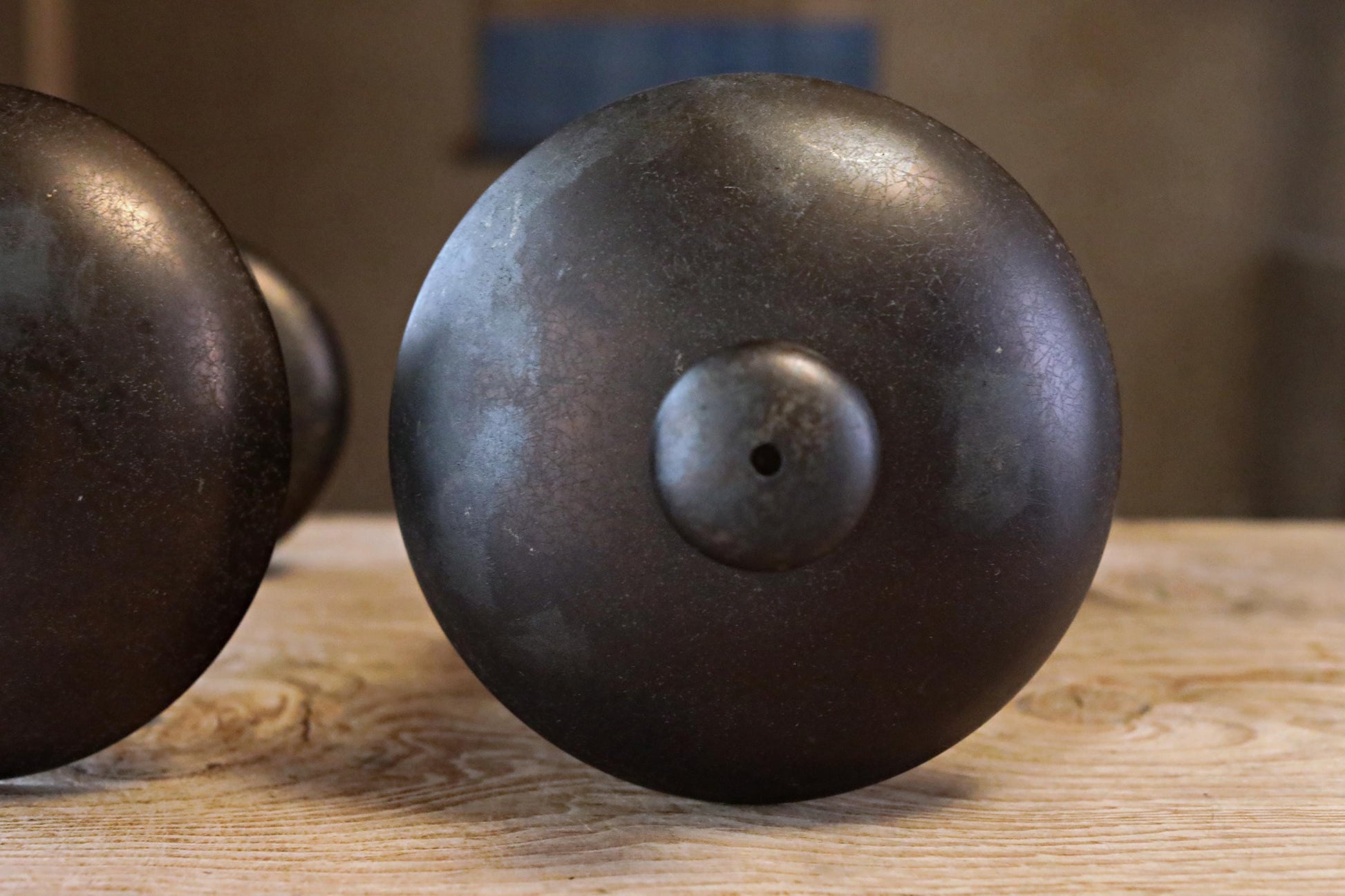 a close-up view of a black metal object, possibly a piece of furniture or a decorative item, placed on a wooden surface.