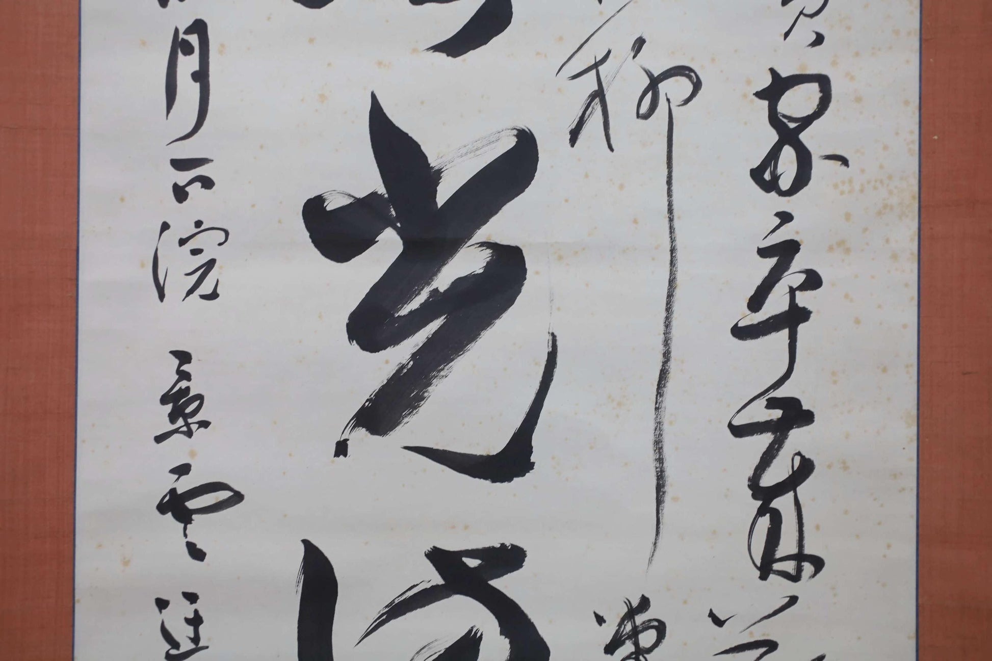 a close-up view of a piece of Chinese calligraphy on a white background. The calligraphy is in black ink and features various characters and strokes, creating a visually striking and intricate design.
