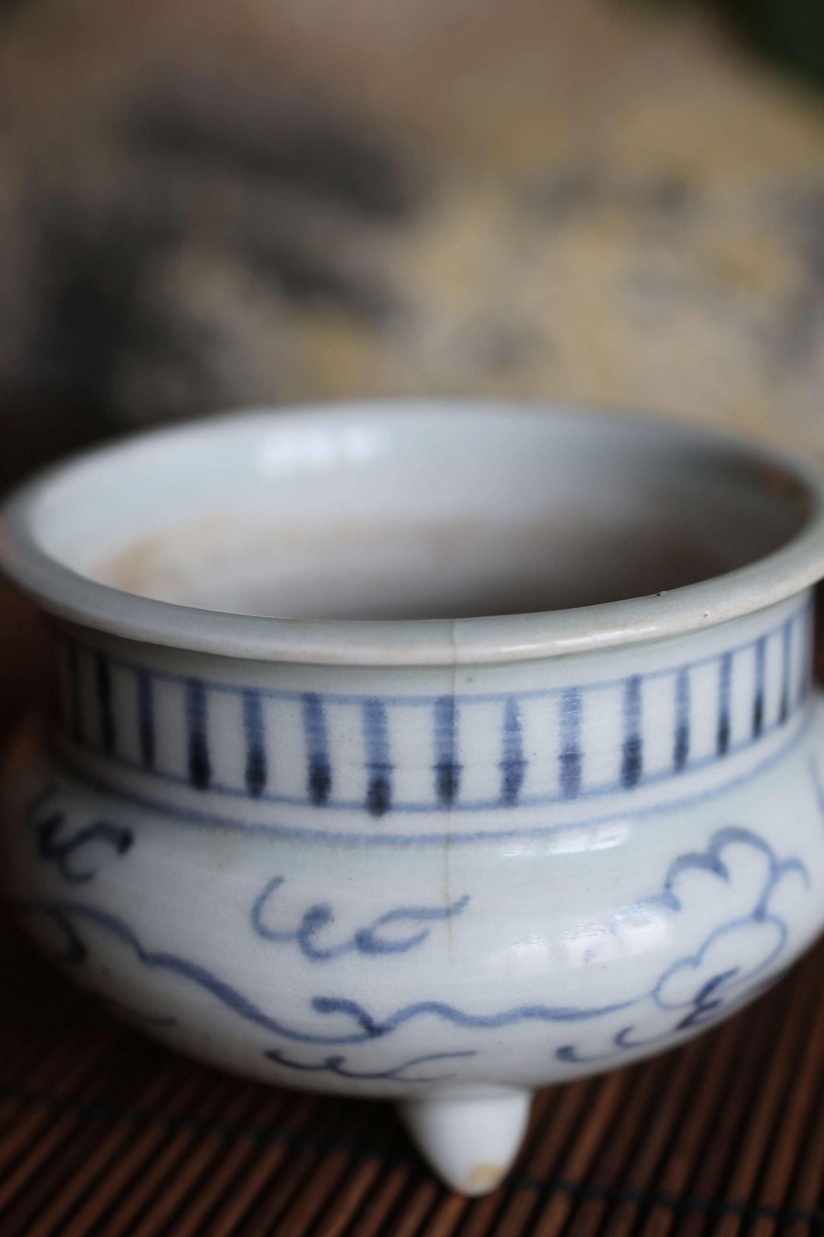 A white ceramic bowl with blue and black decorative patterns, sitting on a wooden surface.