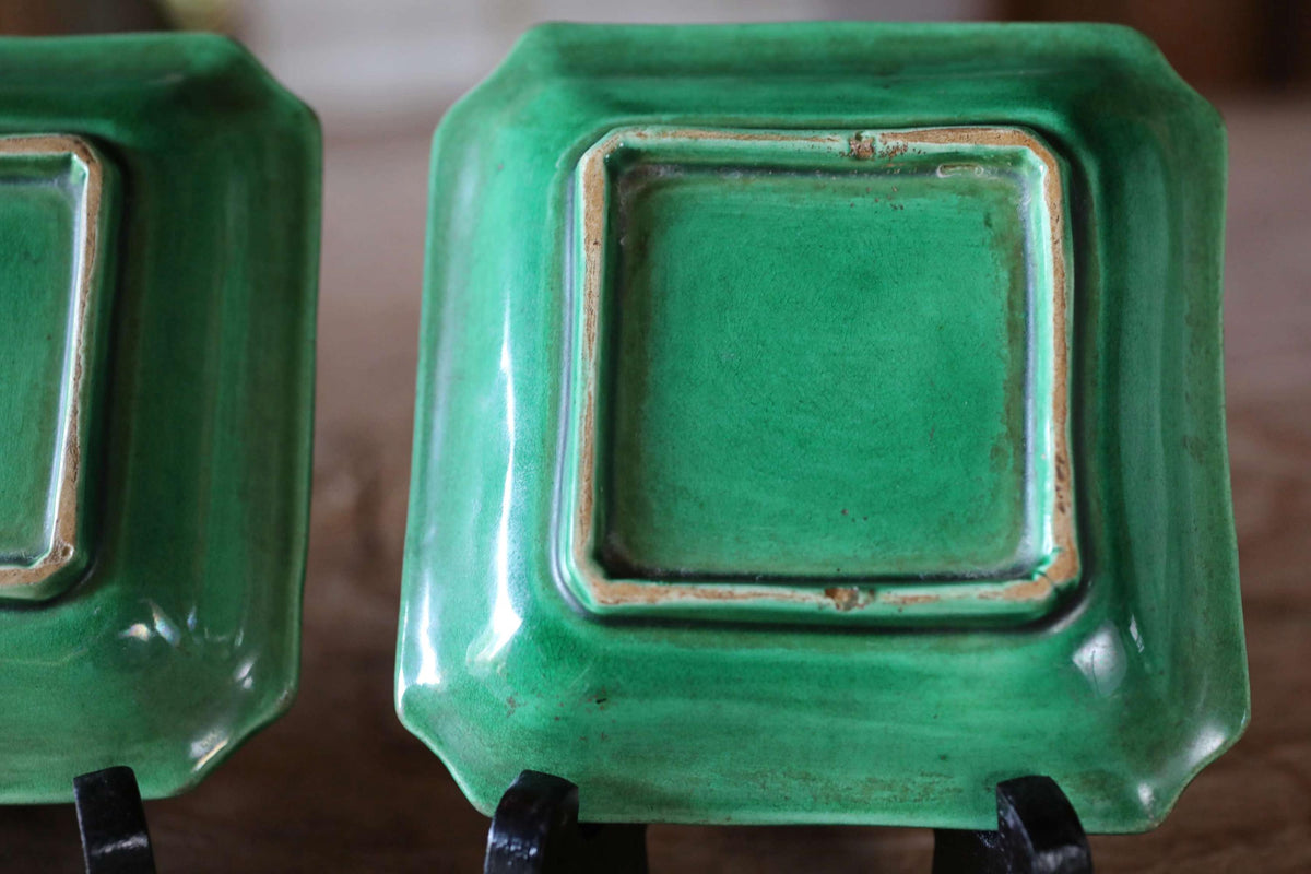 a pair of green square plates with a textured surface.