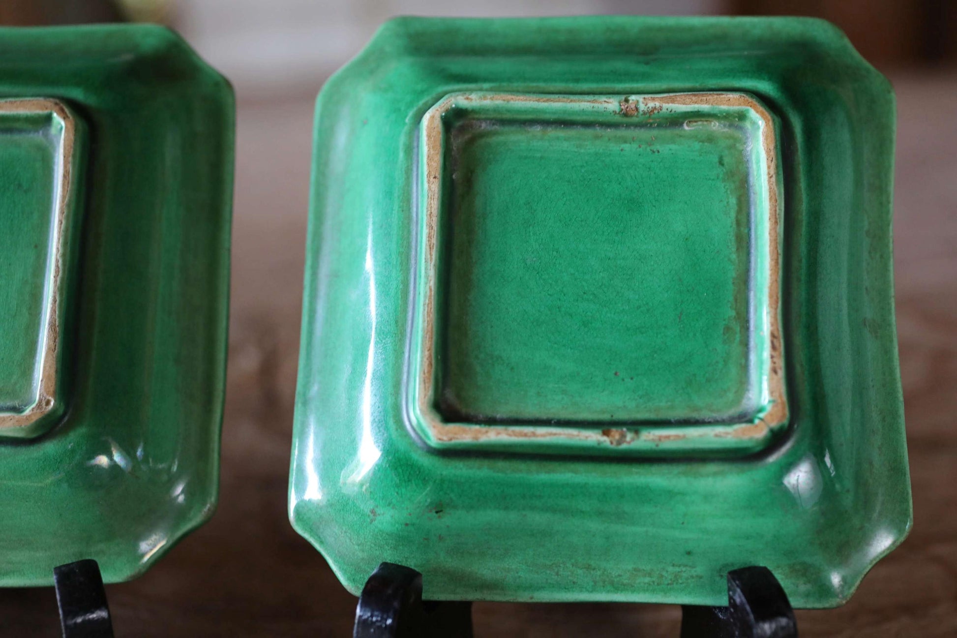 a pair of green square plates with a textured surface.