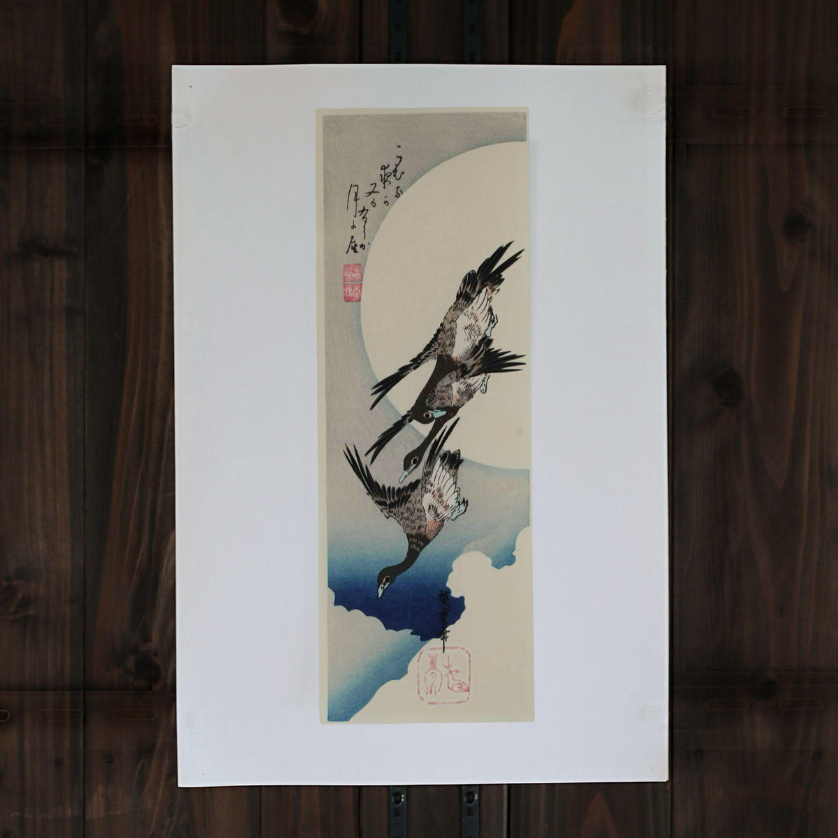 The image is a framed artwork depicting a pair of birds in flight, with a large white circle in the background.