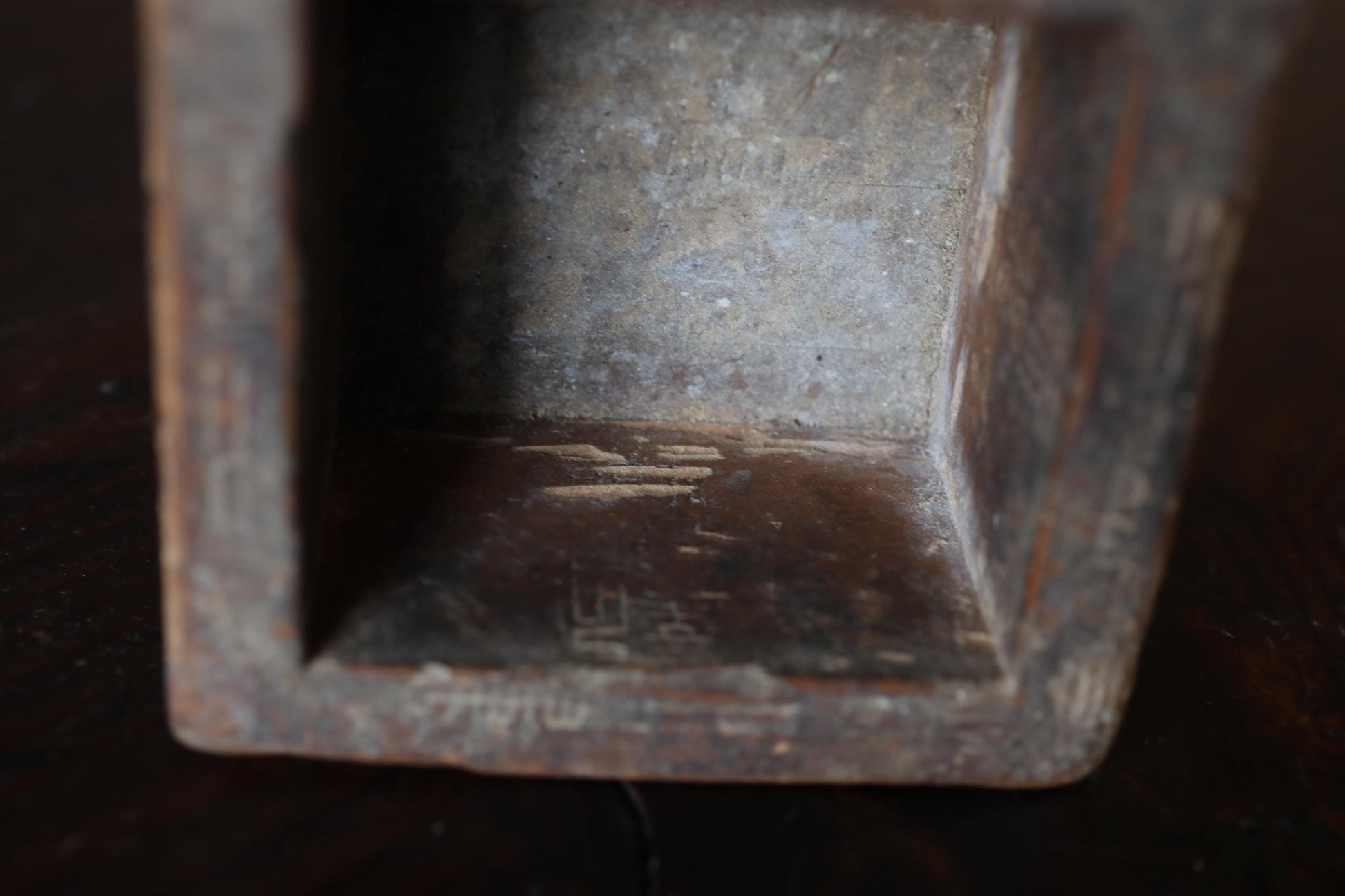 a close-up view of a wooden object, possibly a box or a container, with visible signs of wear and tear, such as rust and peeling paint.