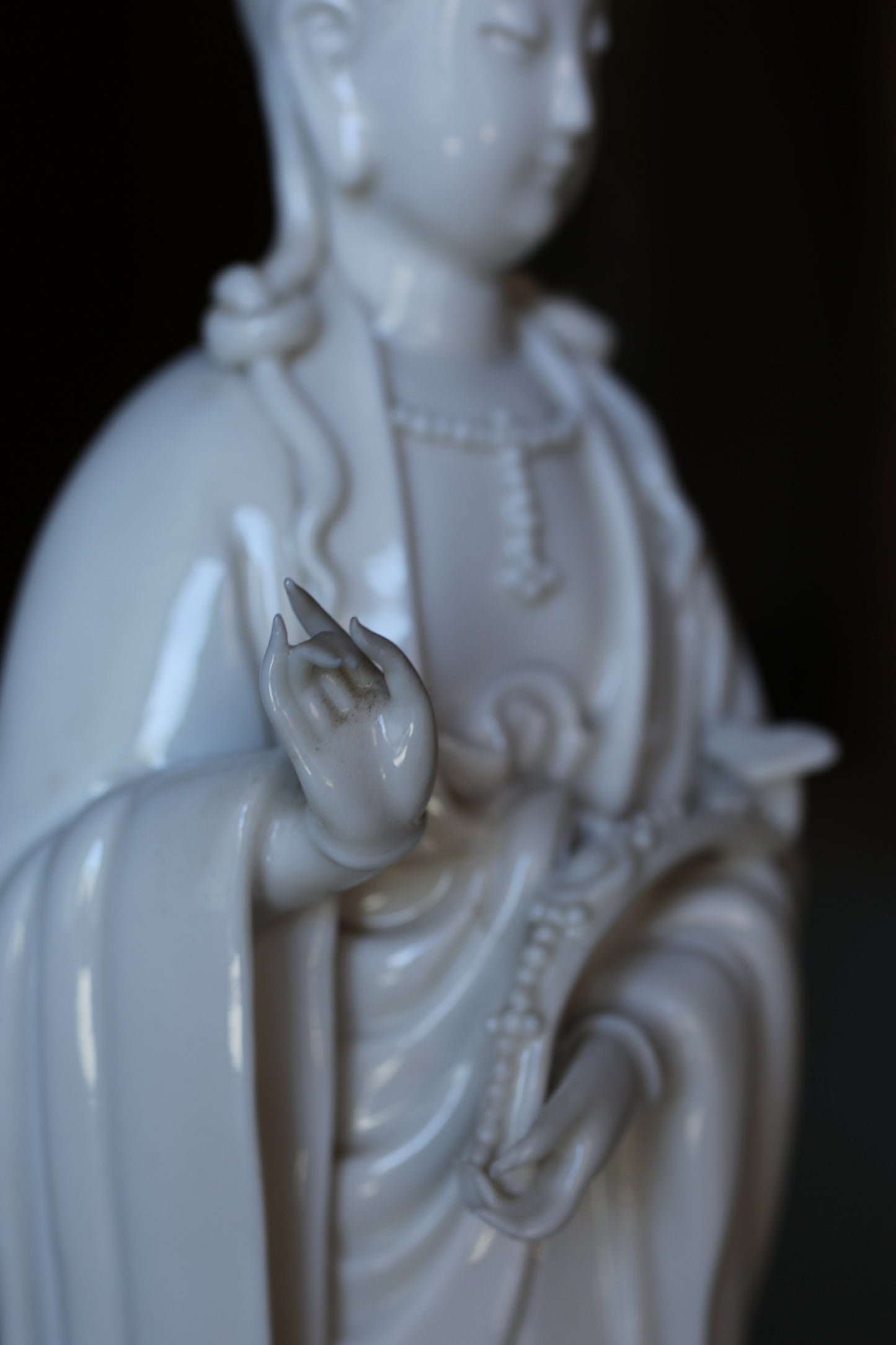 A close-up view of a white ceramic statue depicting a deity or religious figure.