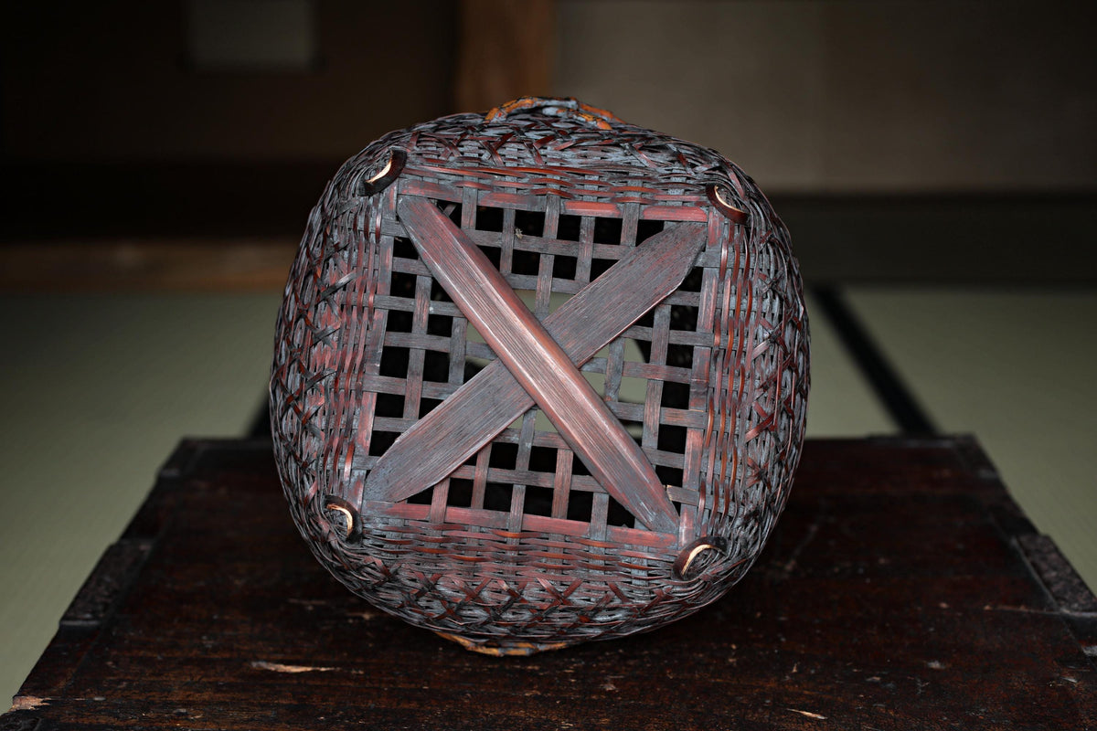 a round, woven basket with a wooden frame, placed on a wooden surface.