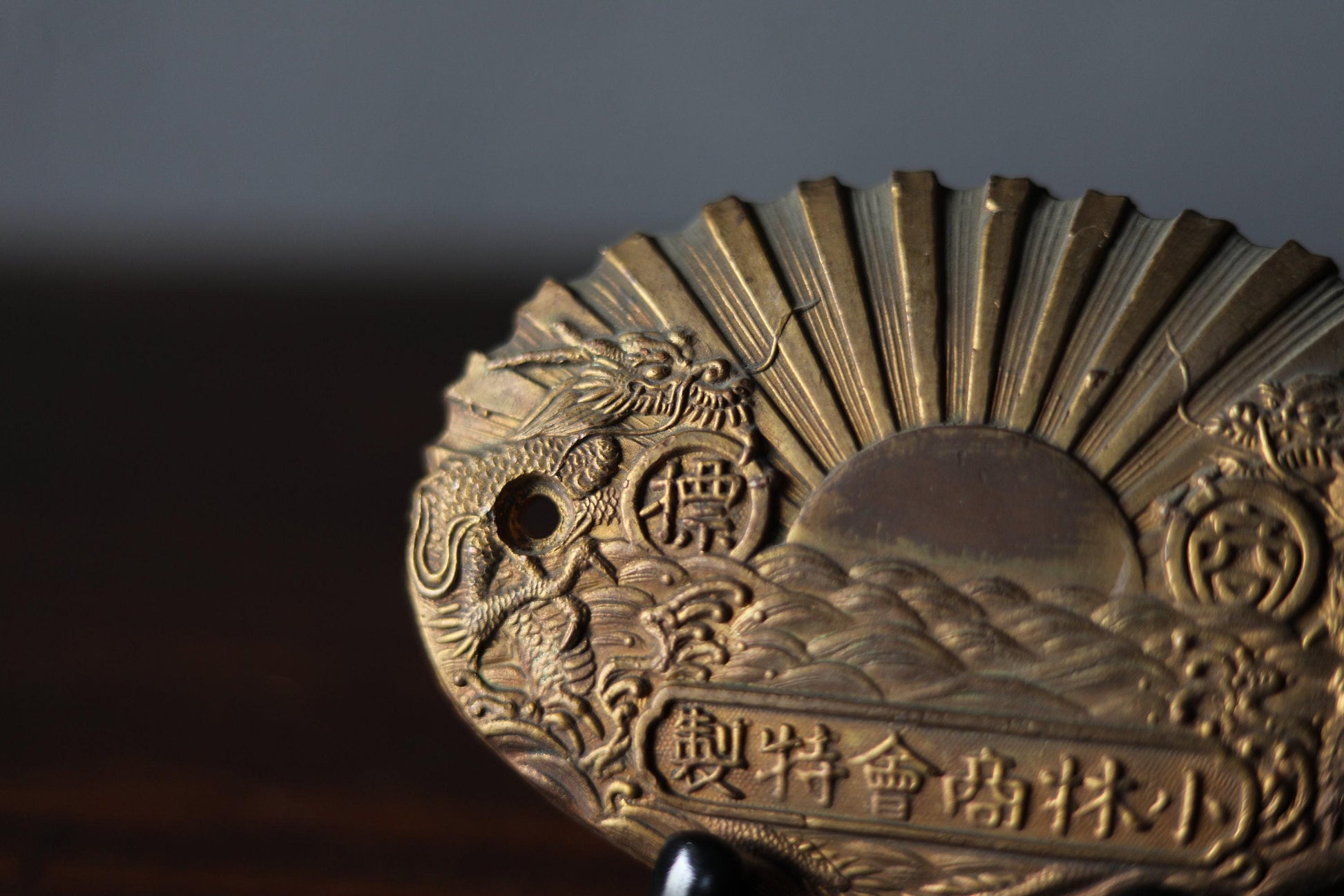 a close-up view of a decorative metal object, possibly a fan or a piece of jewelry, with intricate designs and patterns.