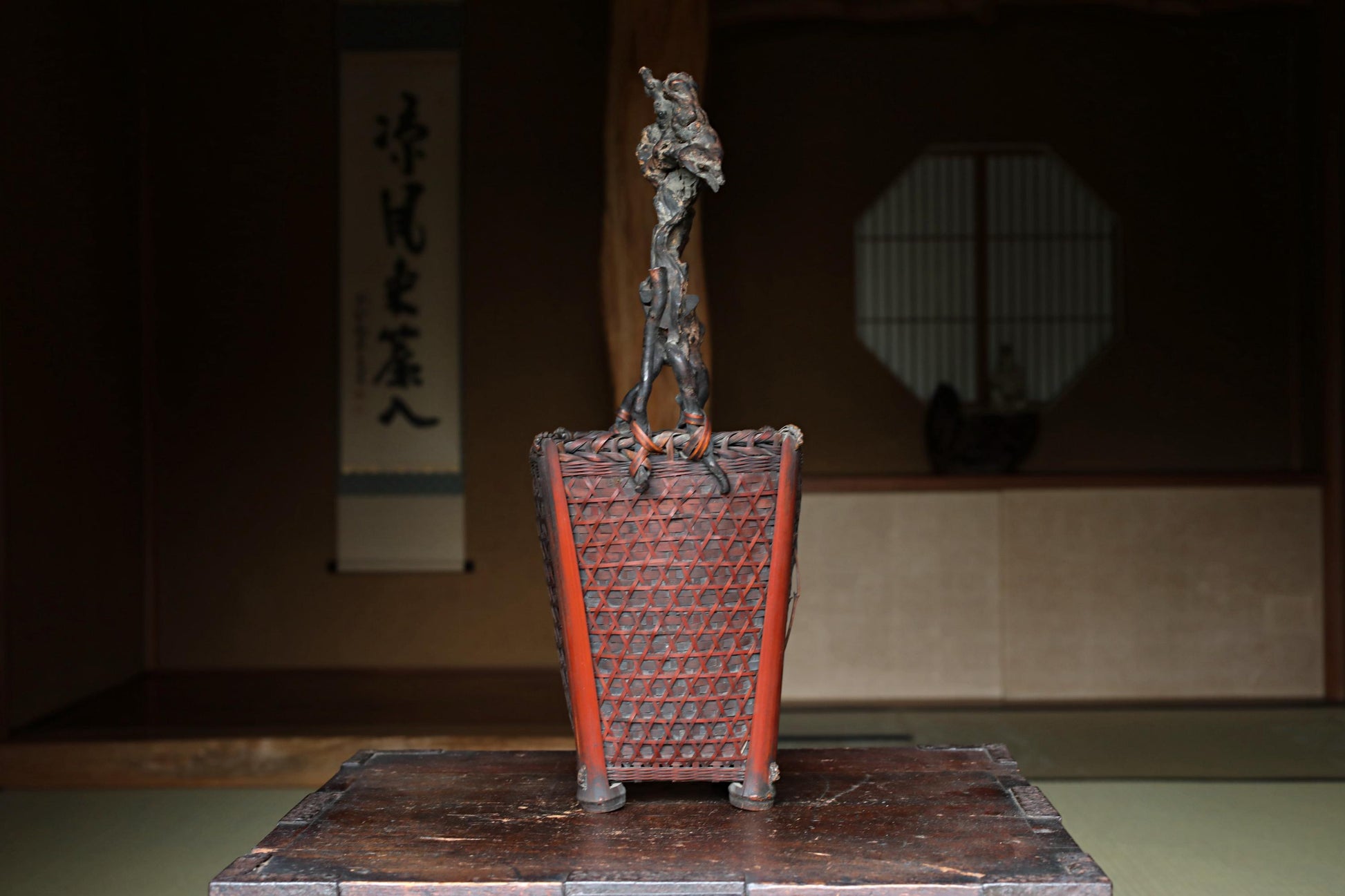 a wooden table with a decorative metal sculpture on top, which appears to be a traditional Japanese-style object.