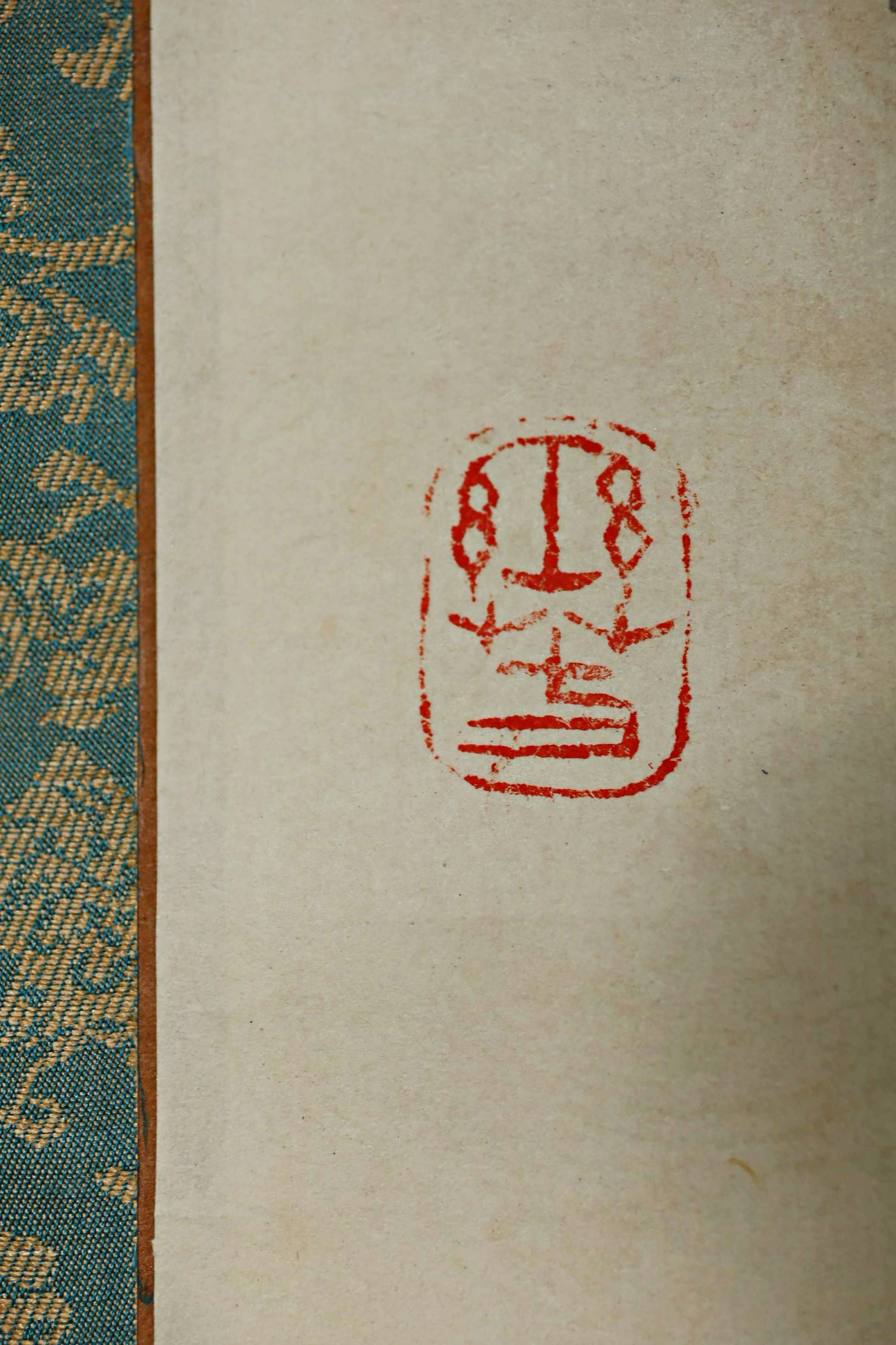 a red stamp with a symbol on a white background.