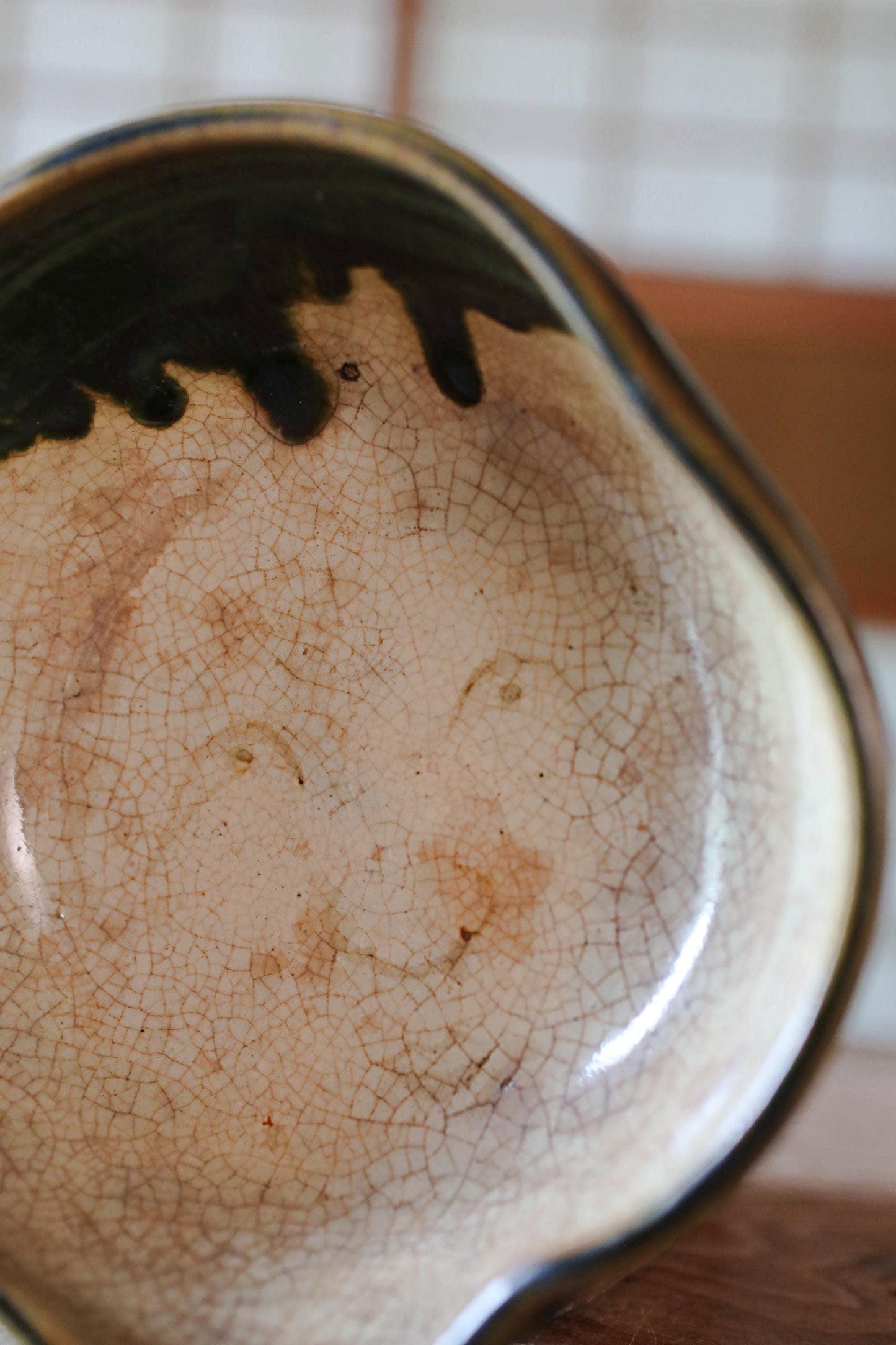 A close-up image of a ceramic bowl with a face drawn on it, featuring a smiley face.