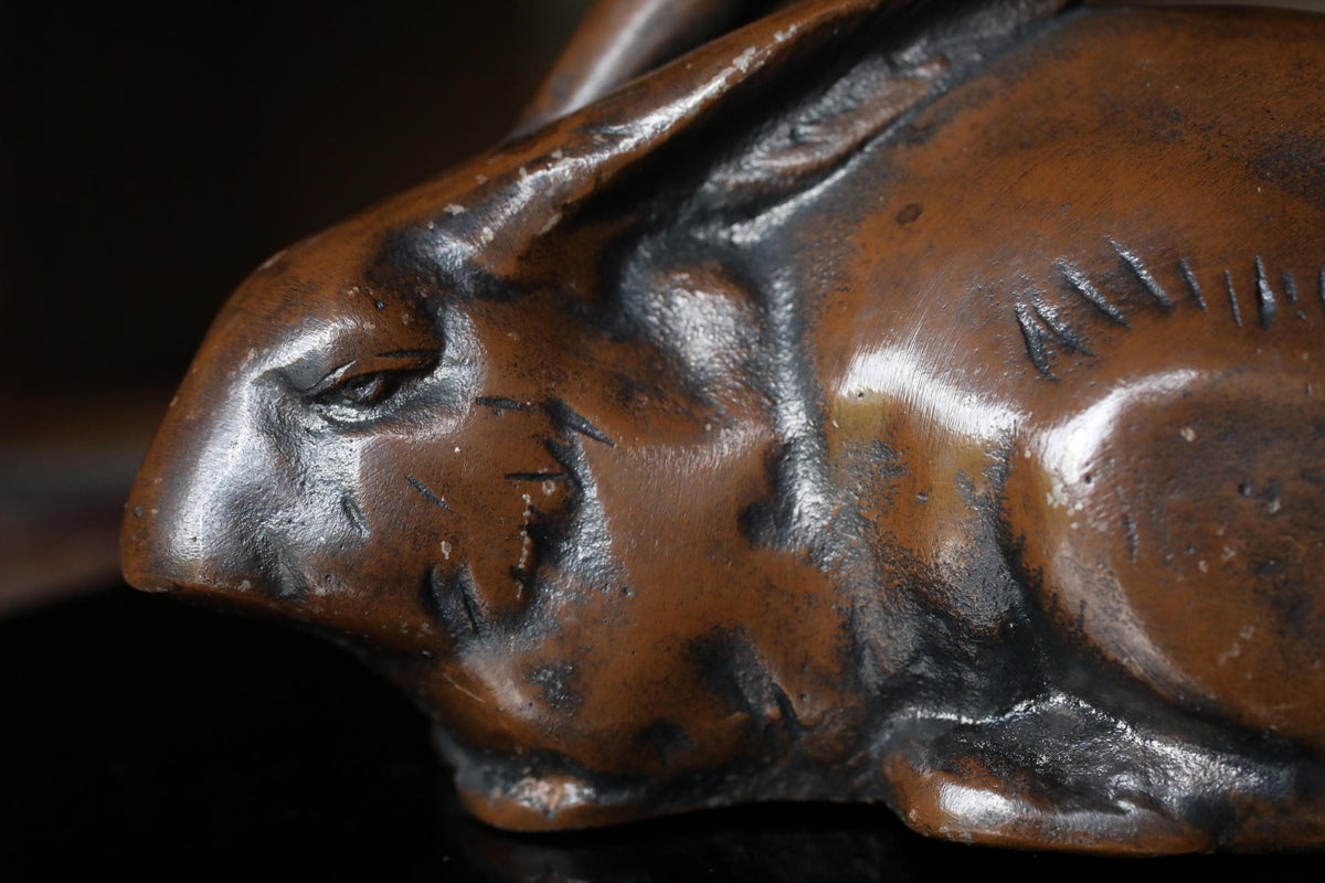 A close-up image of a bronze sculpture of a rabbit or similar animal, with intricate details and a textured surface.